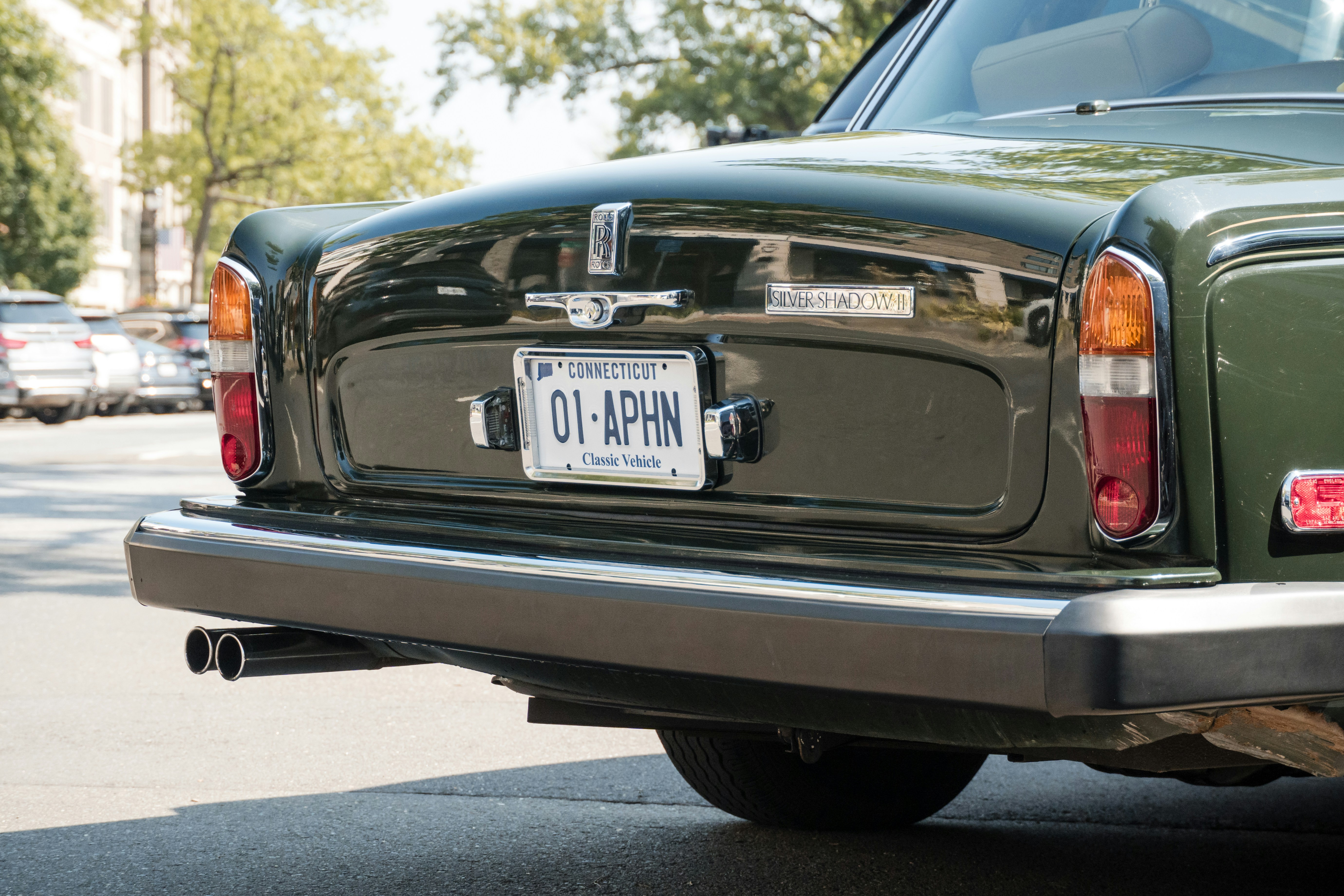 The back of a vintage green car is shown.