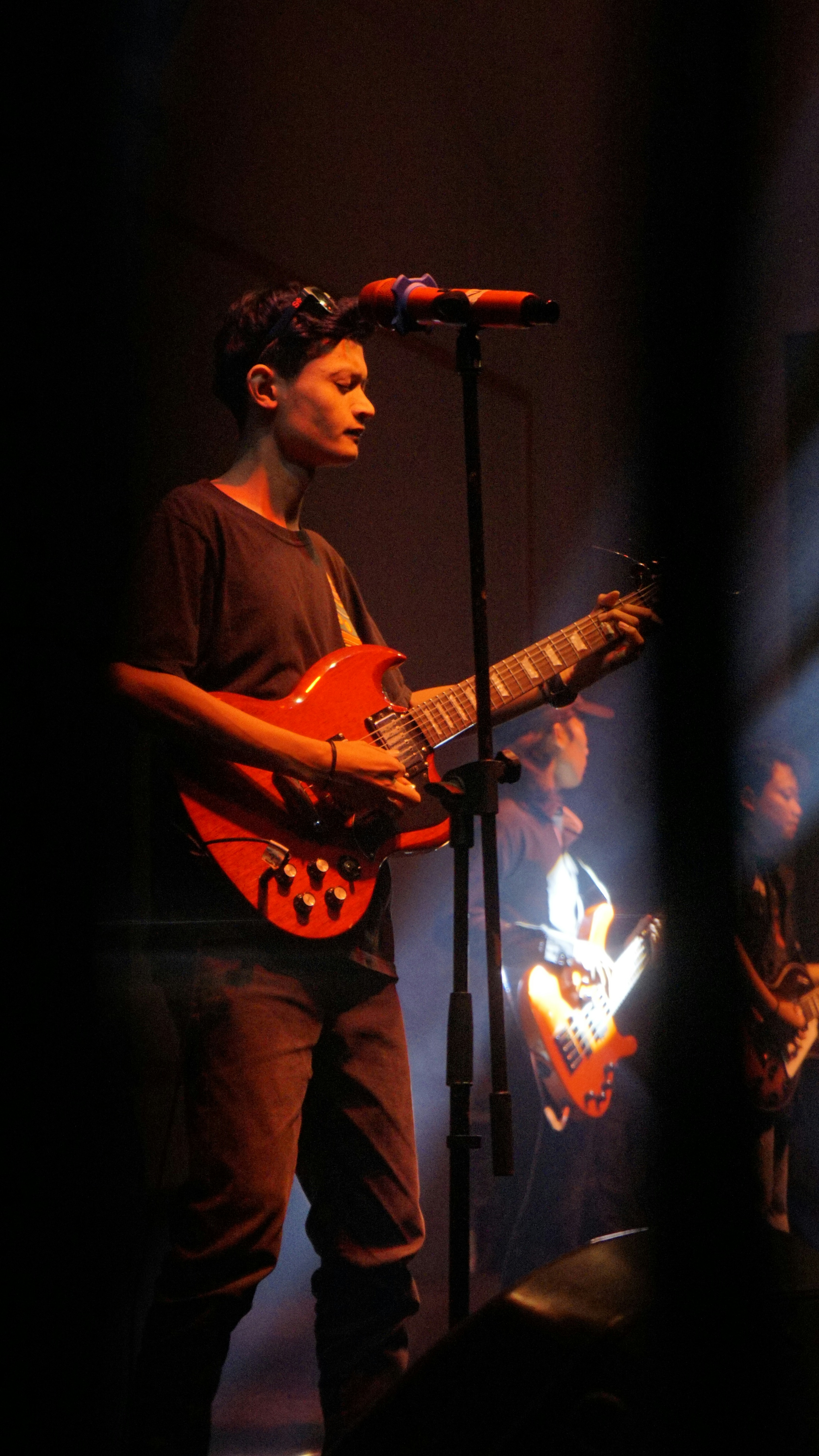 A musician performs on stage with their guitar.