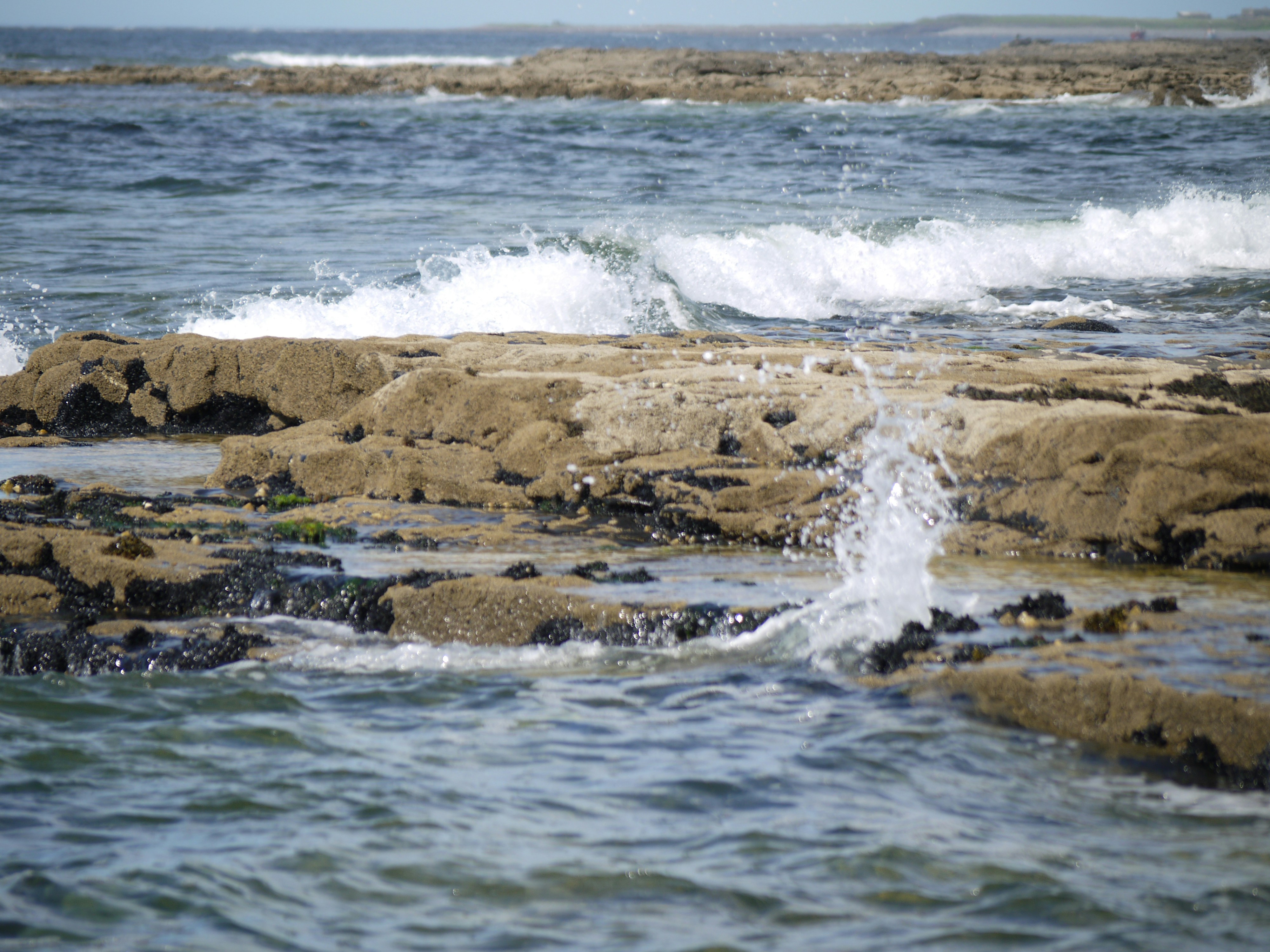 Waves crash against the rocky shoreline.