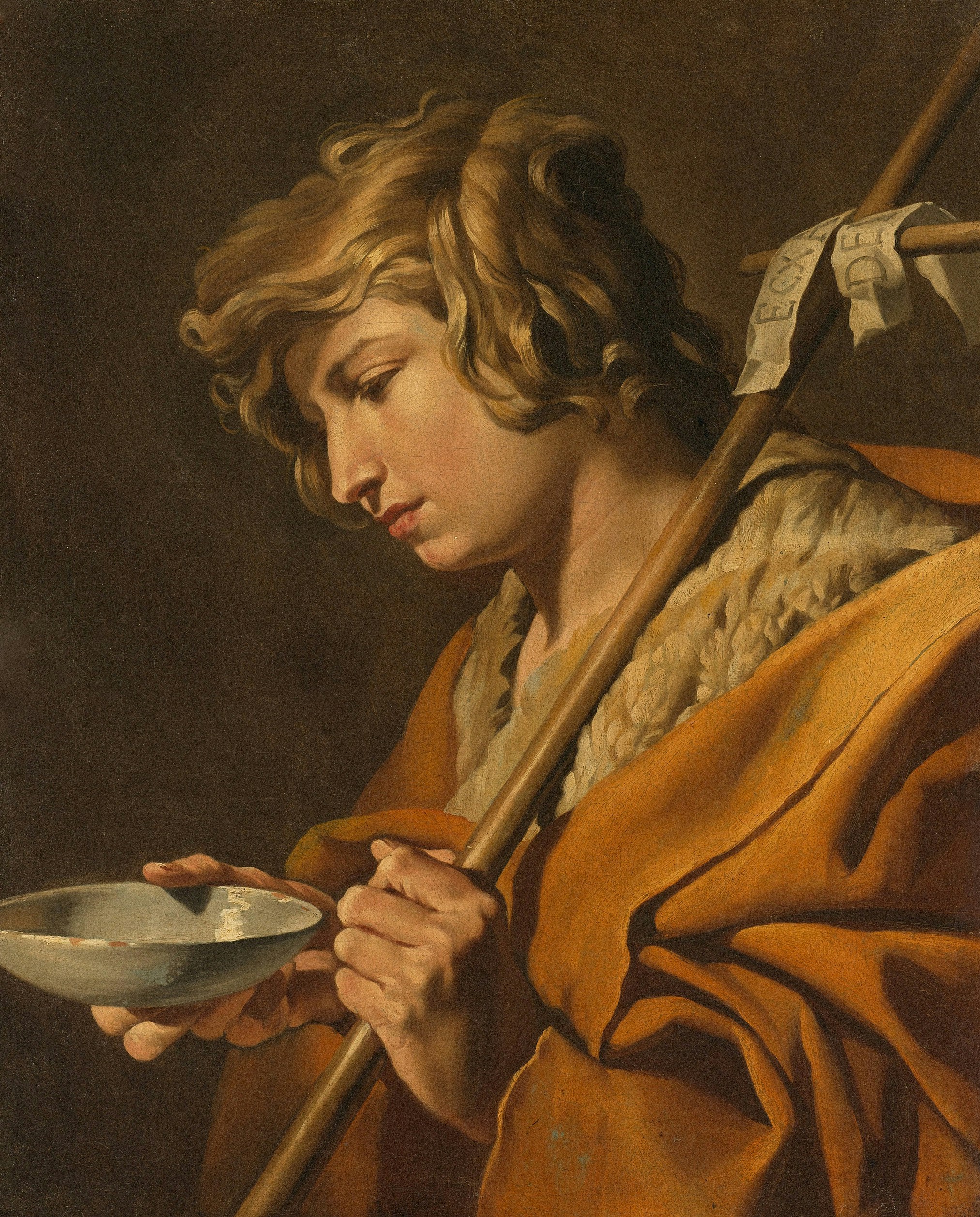 Young man with staff and bowl in orange robe