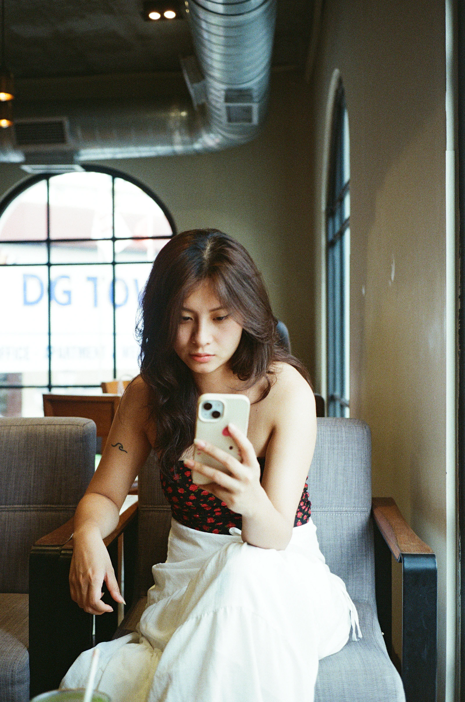 Woman over 50 sitting in a cafe and looking at her phone while dating again