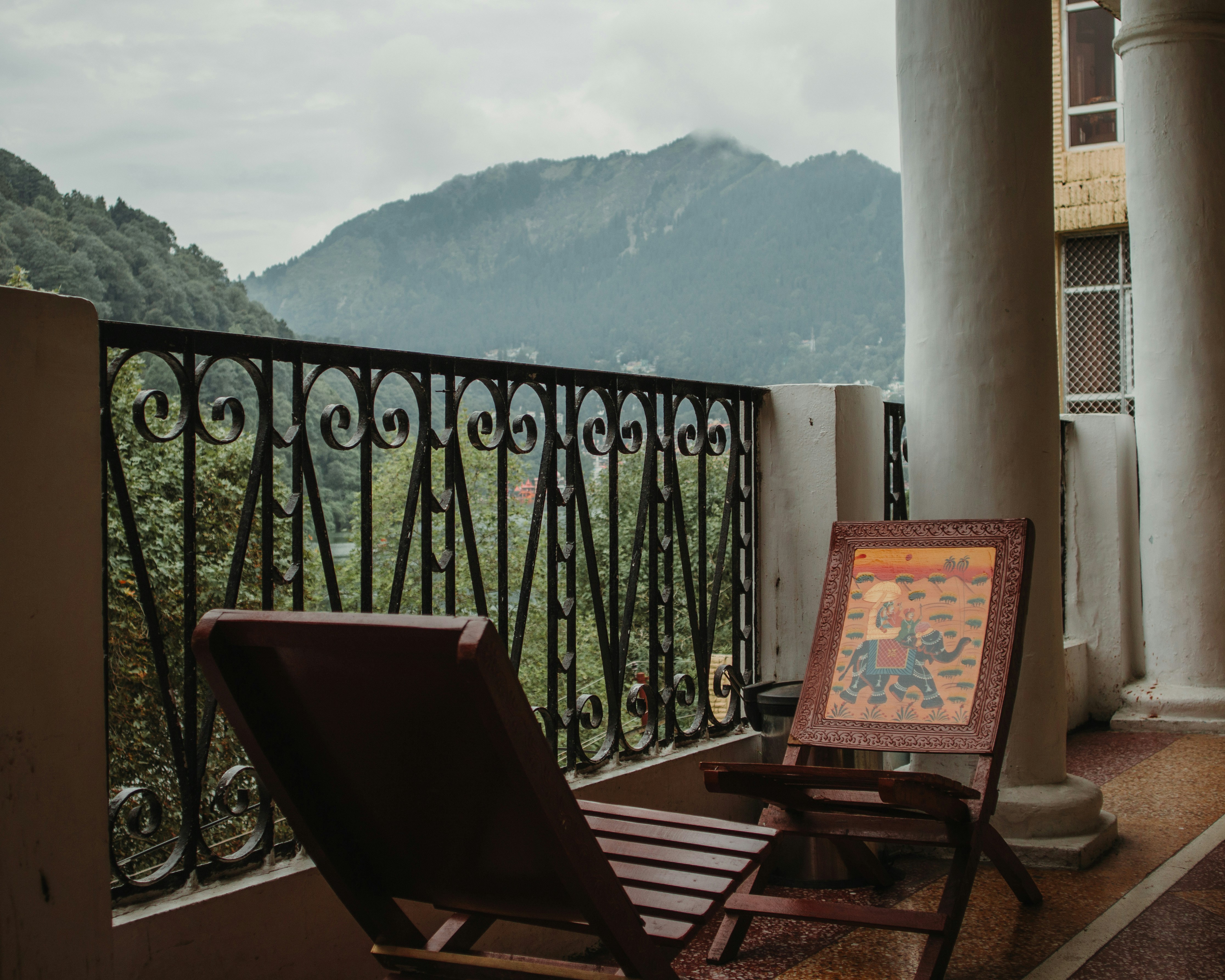 Un balcone con vista sulle montagne e sedie.