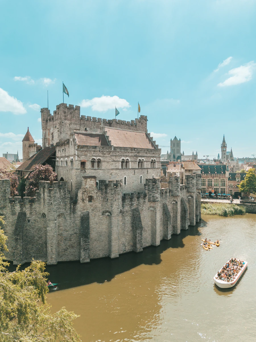 Средневековый замок Gravensteen у воды и лодки на канале