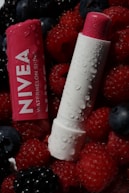 Nivea watermelon shine lip balm sits in fresh berries.