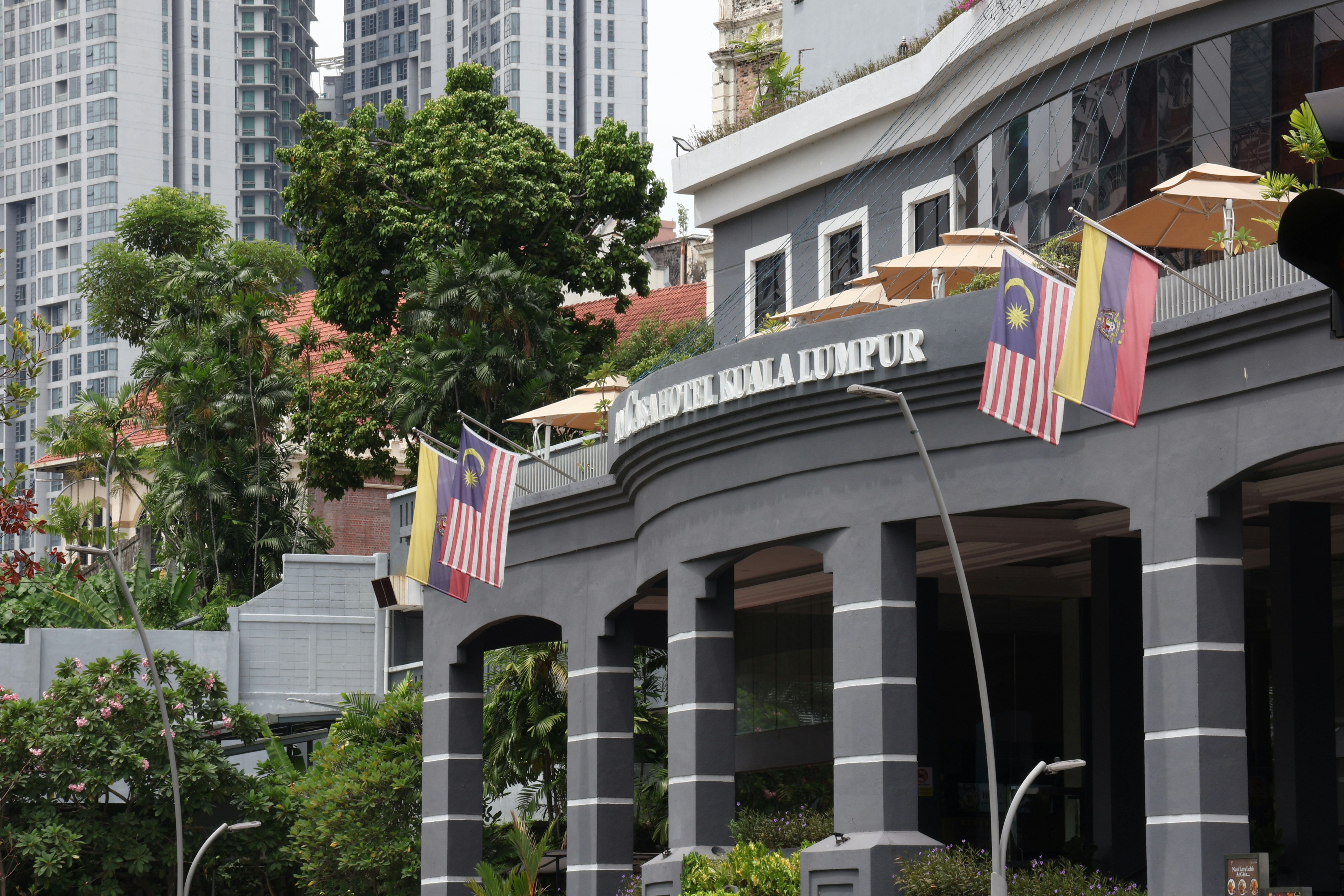 A building with malaysian flags waving.