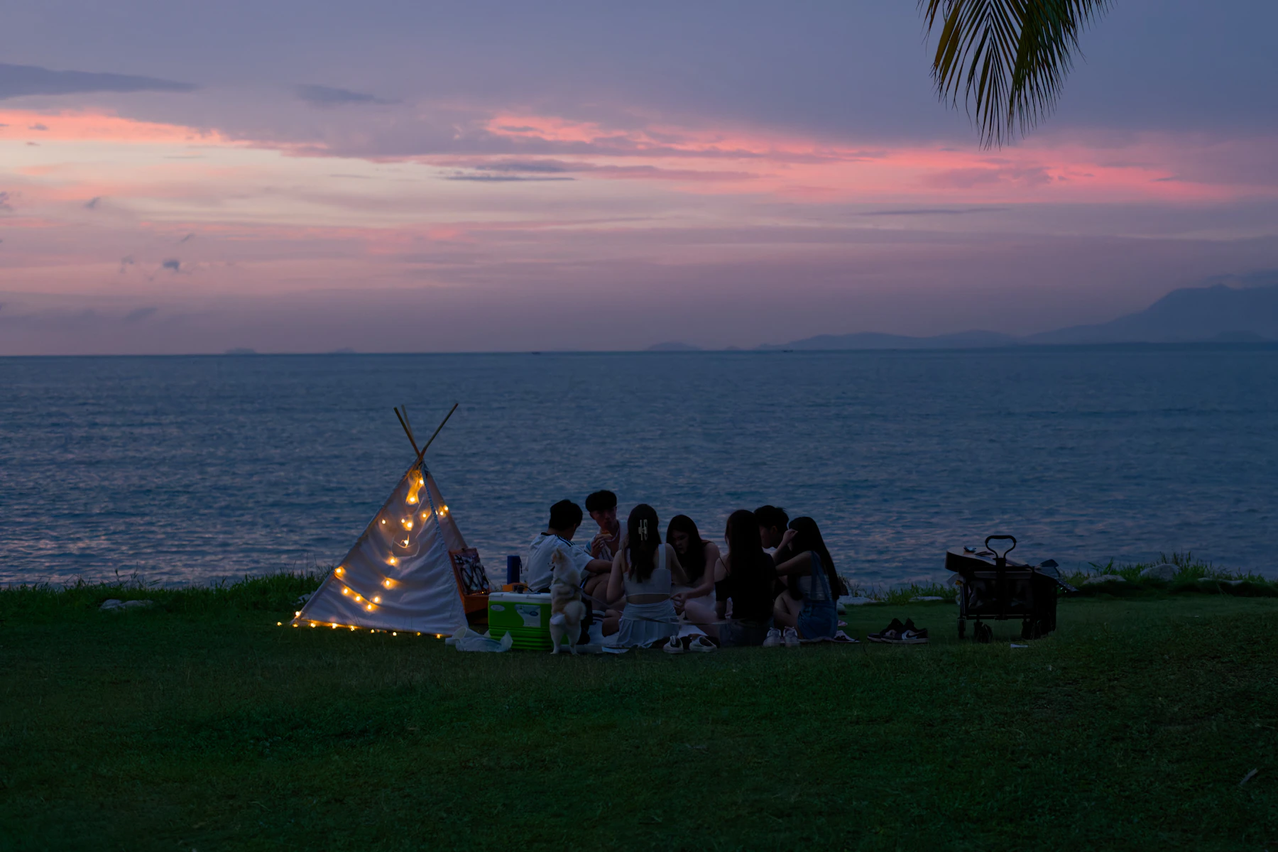 Amigos compartiendo un picnic al atardecer junto al mar