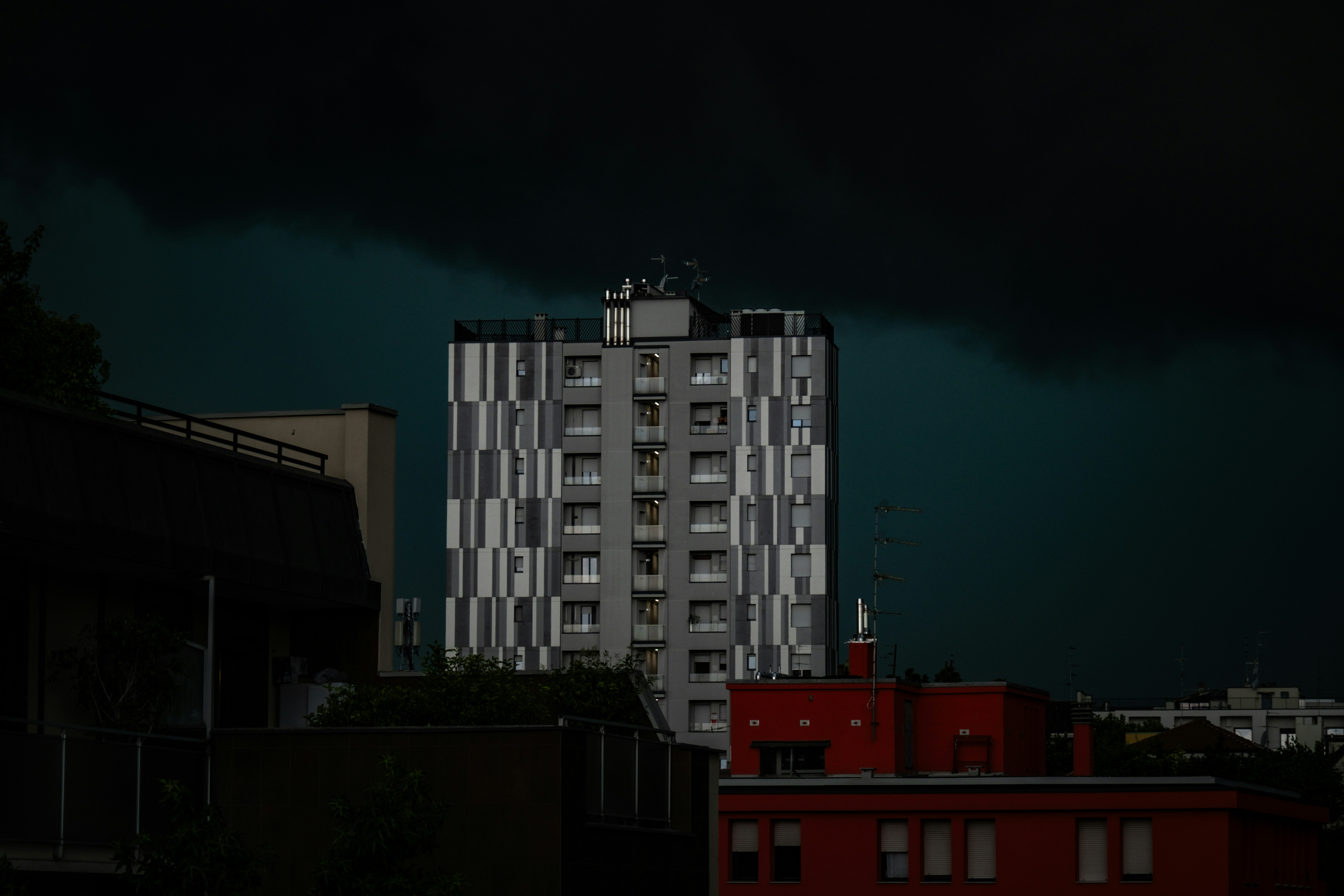 A tall building stands before a stormy sky.
