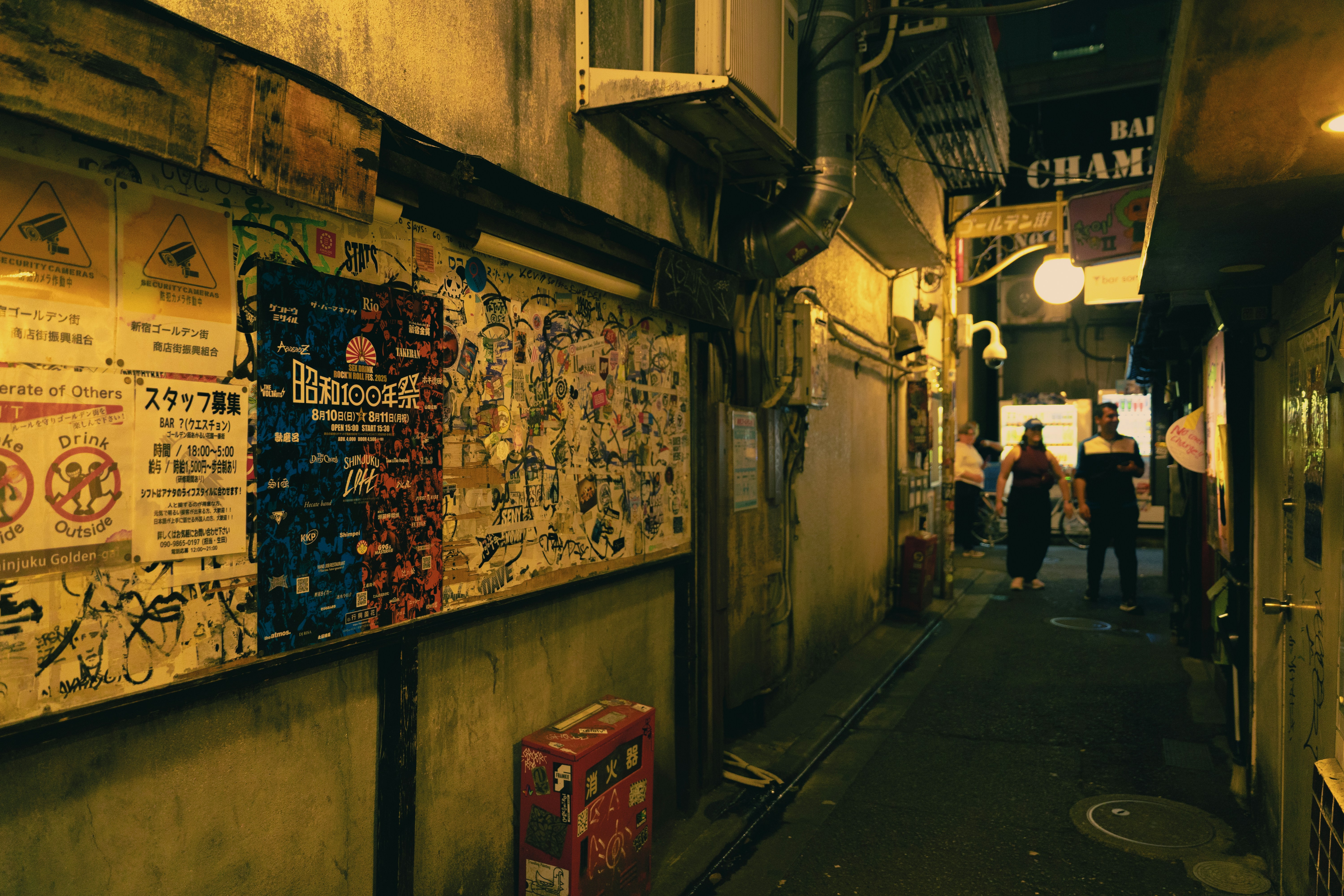 A narrow alleyway illuminated by dim, warm lights.