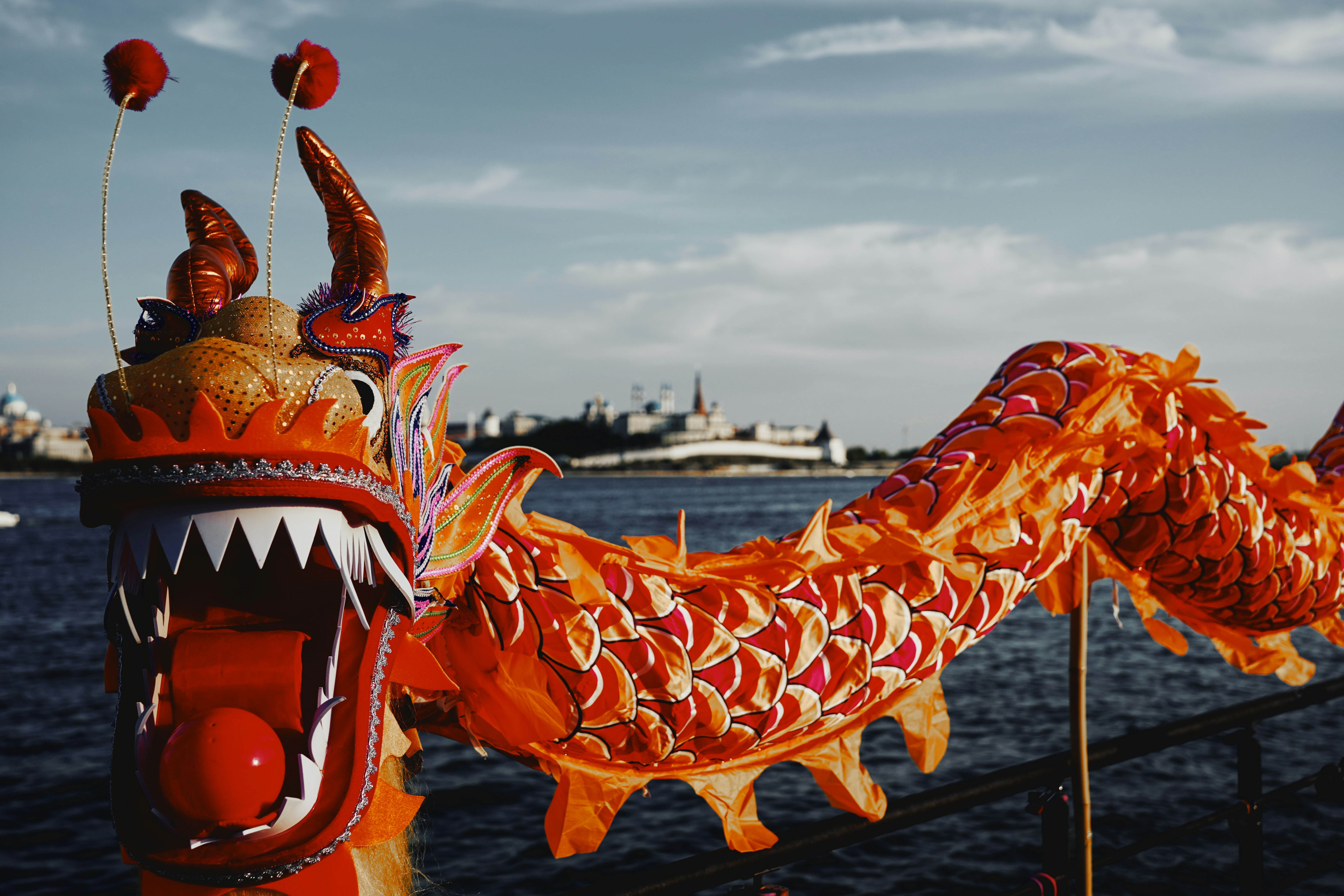 A colorful chinese dragon dances by the water.
