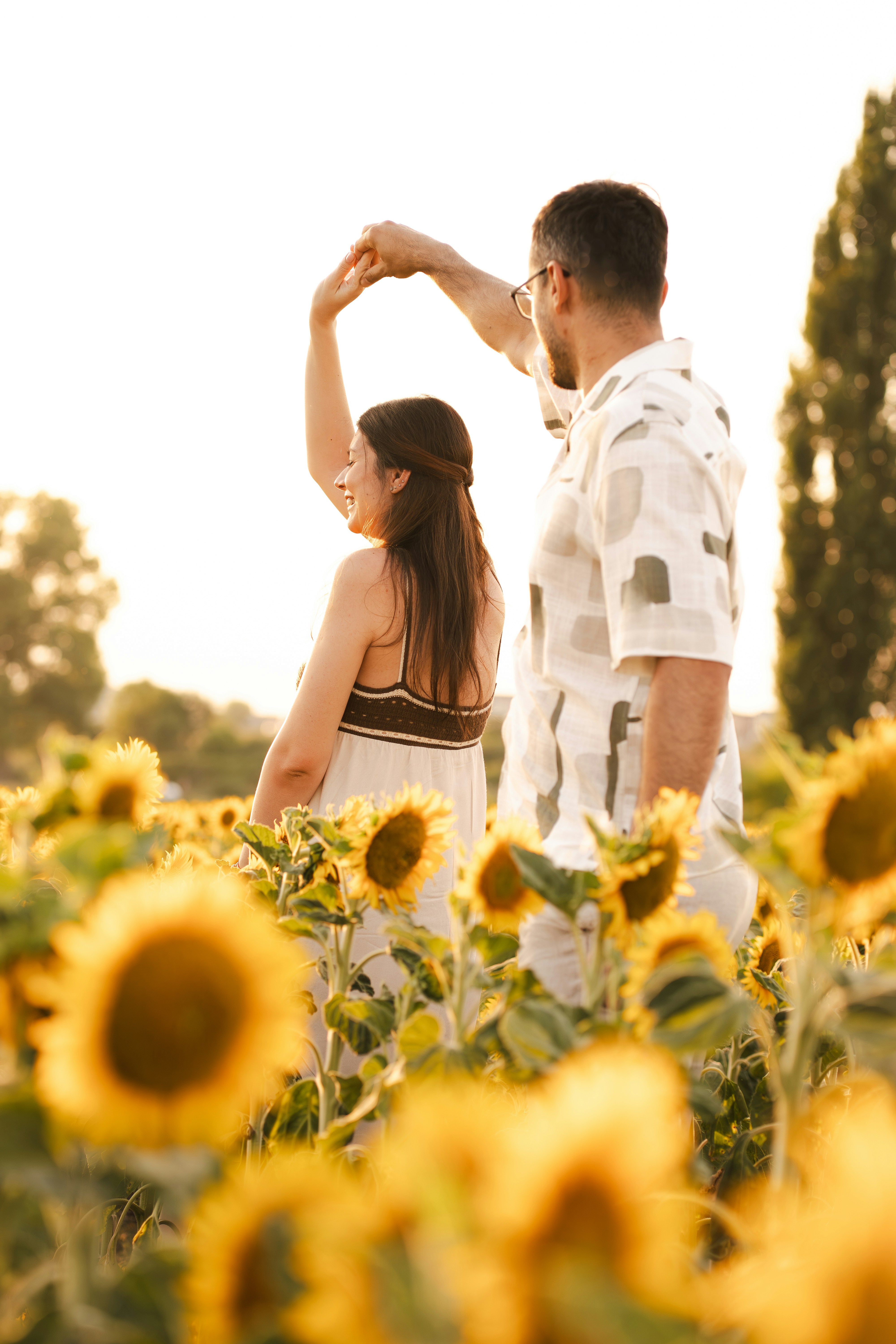 Una pareja baila en un campo de girasoles.