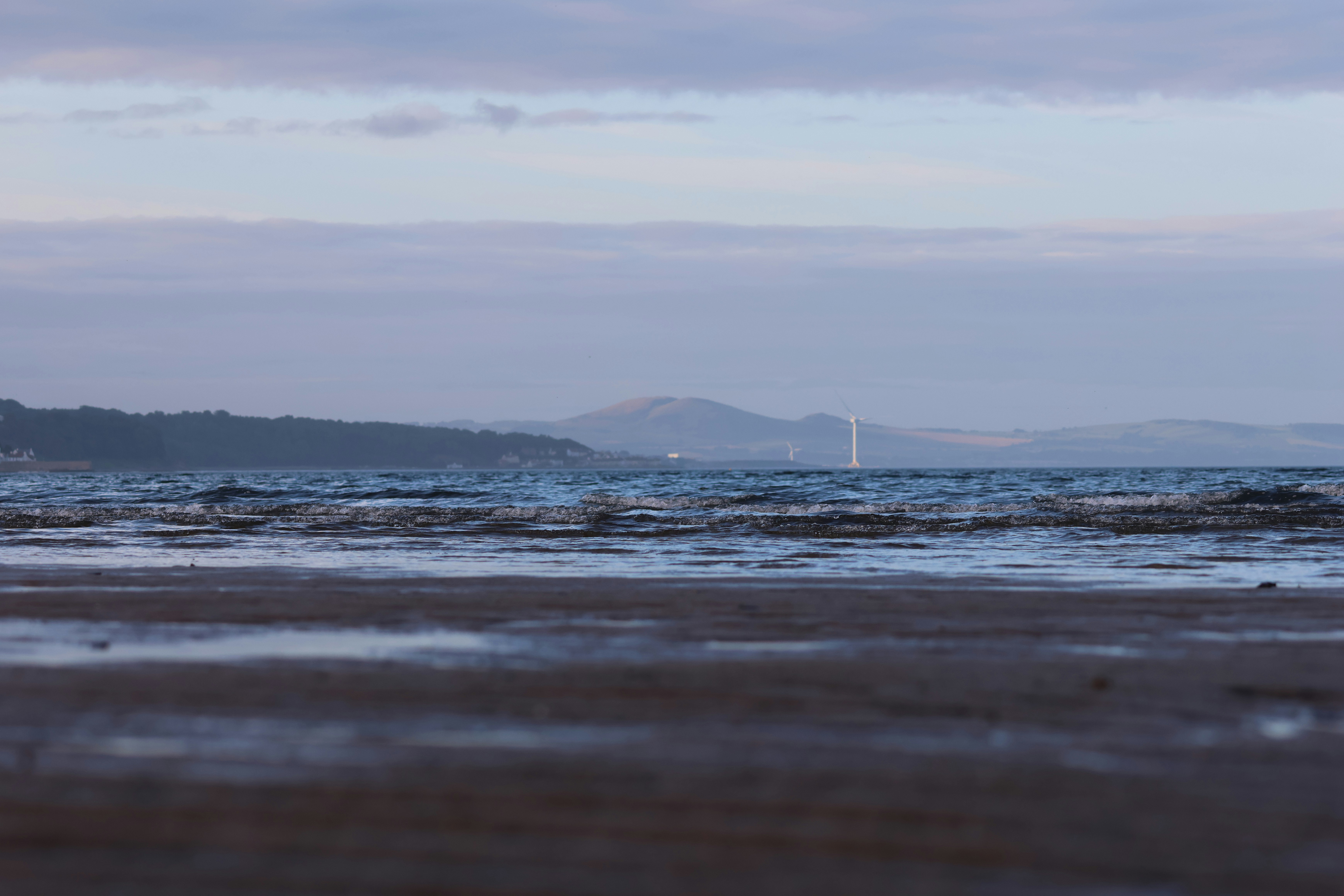 A beach scene with water and a cloudy sky