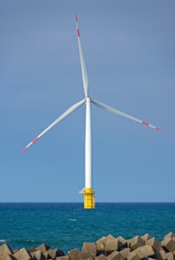 Wind turbine stands tall over the ocean.