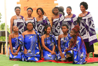 A group of women pose in beautiful traditional attire.