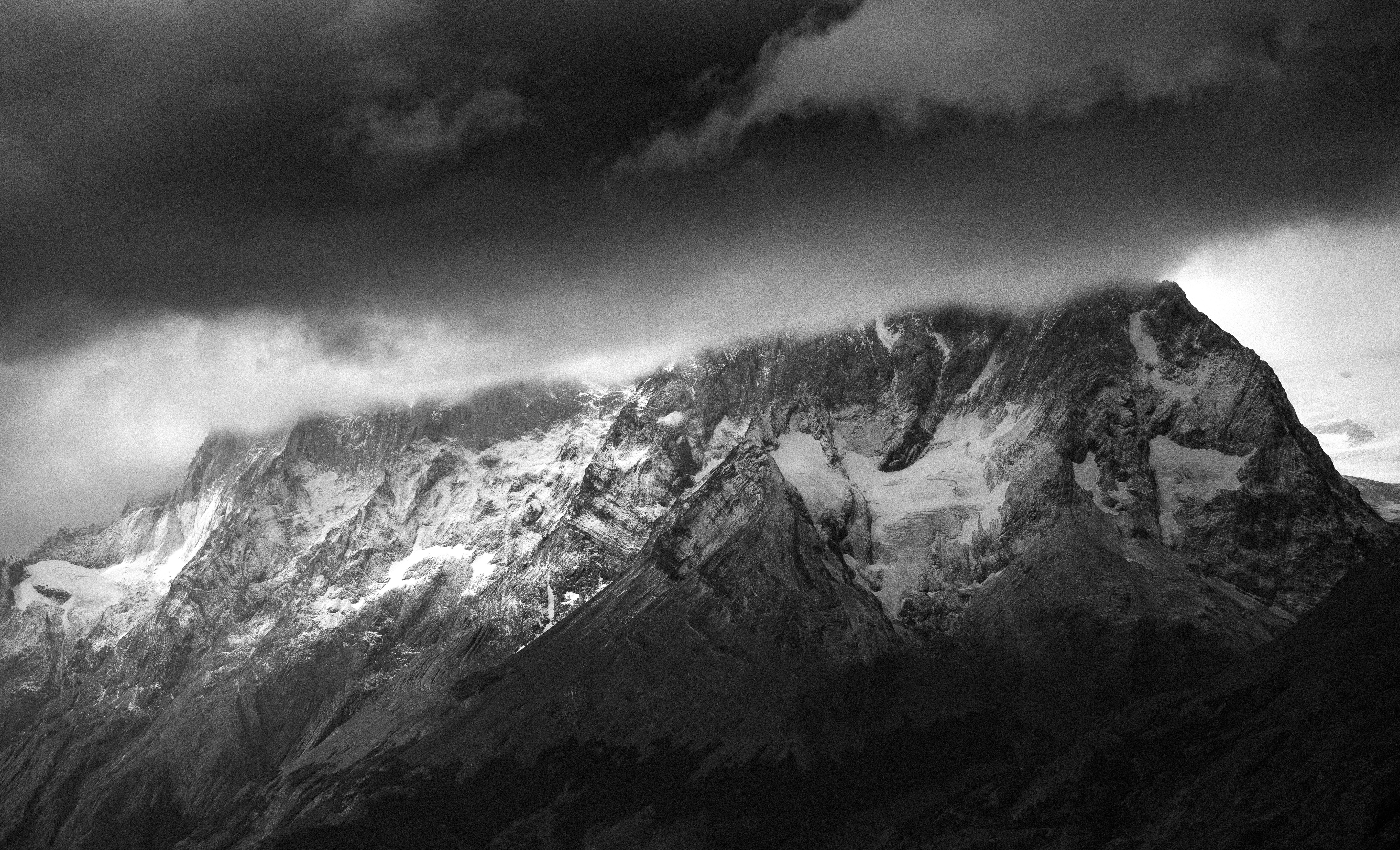 A snowy mountain is hidden under cloudy skies.