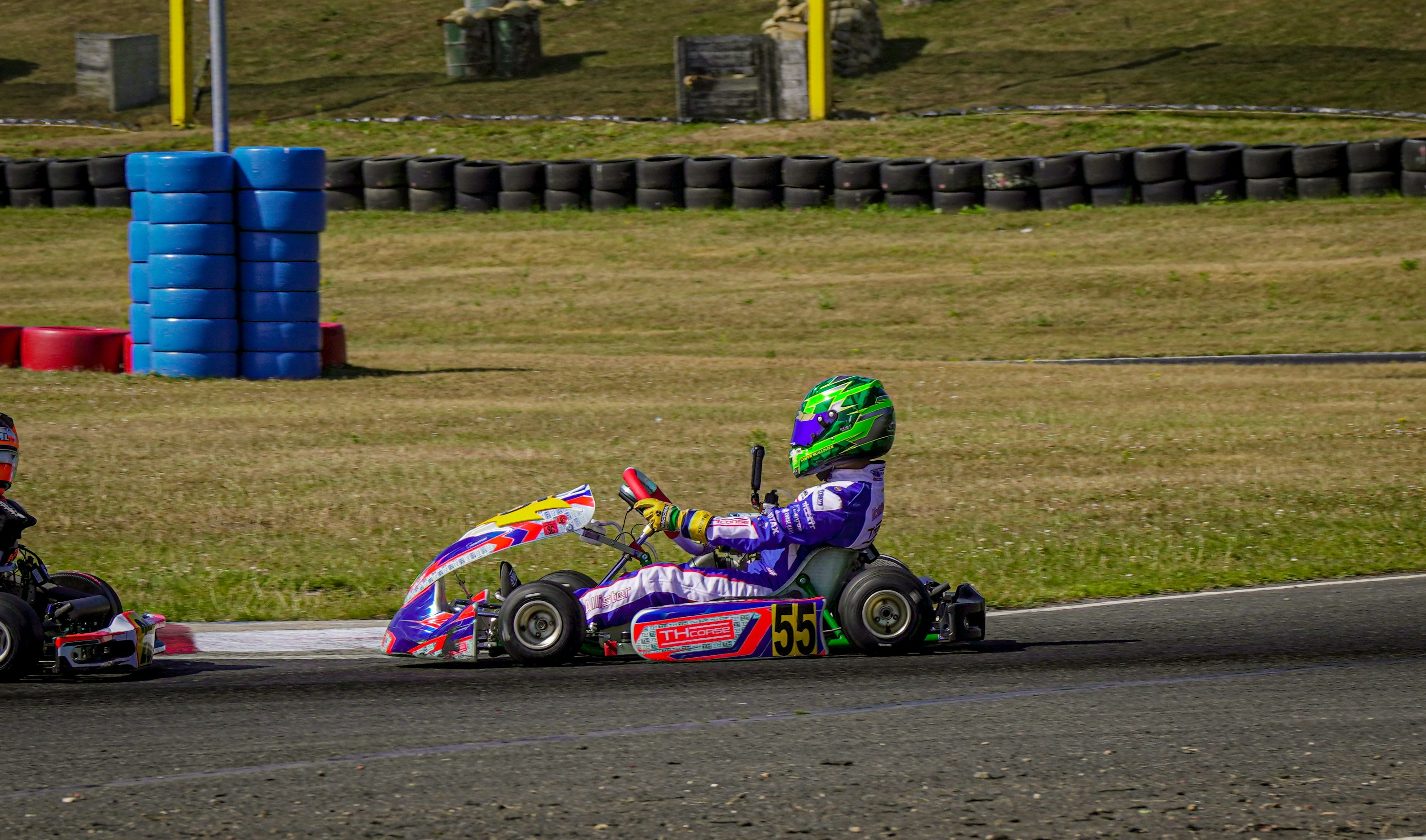 A child in a go-kart races on a track.