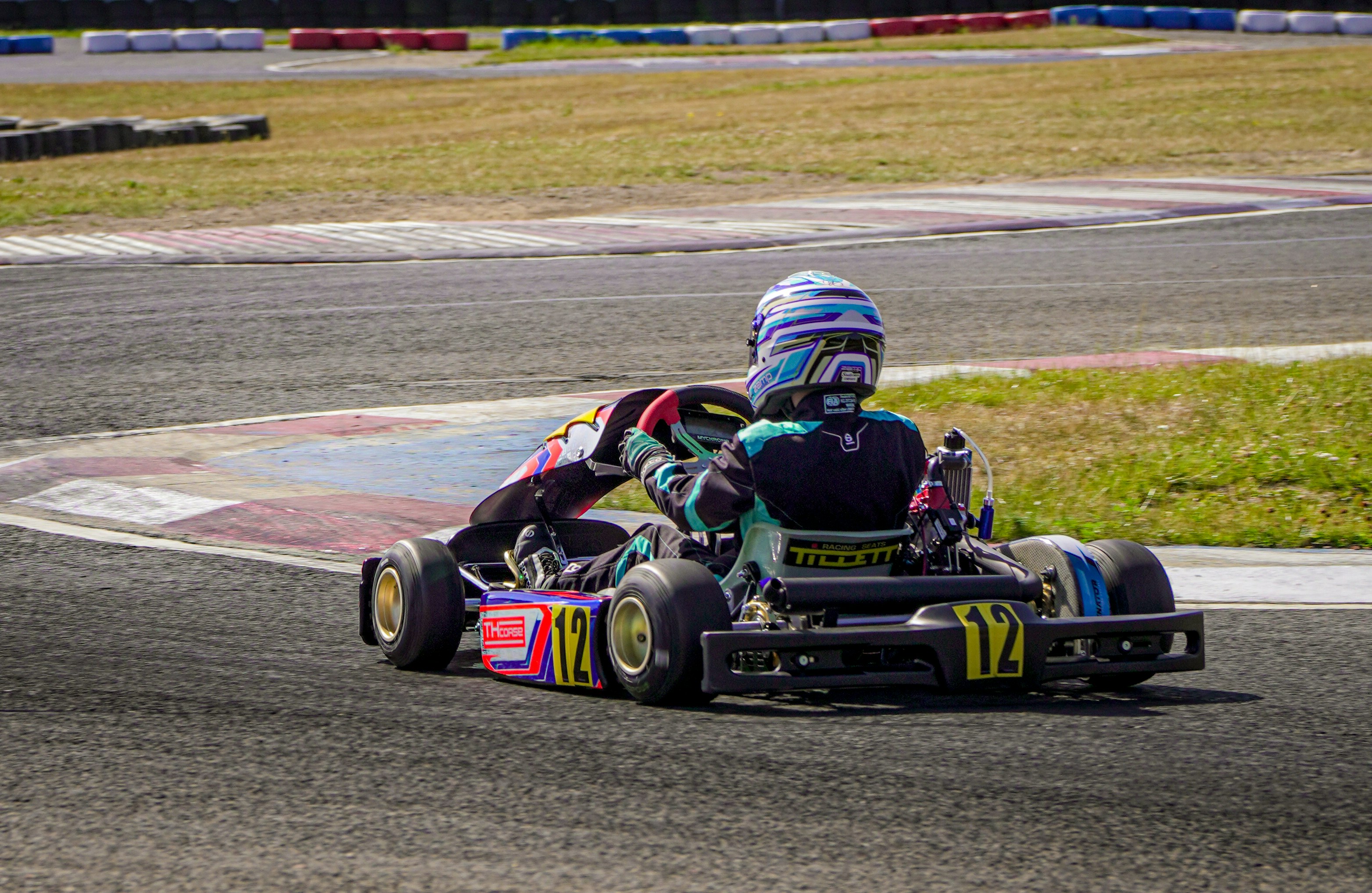 A go-kart racer speeds around a track.