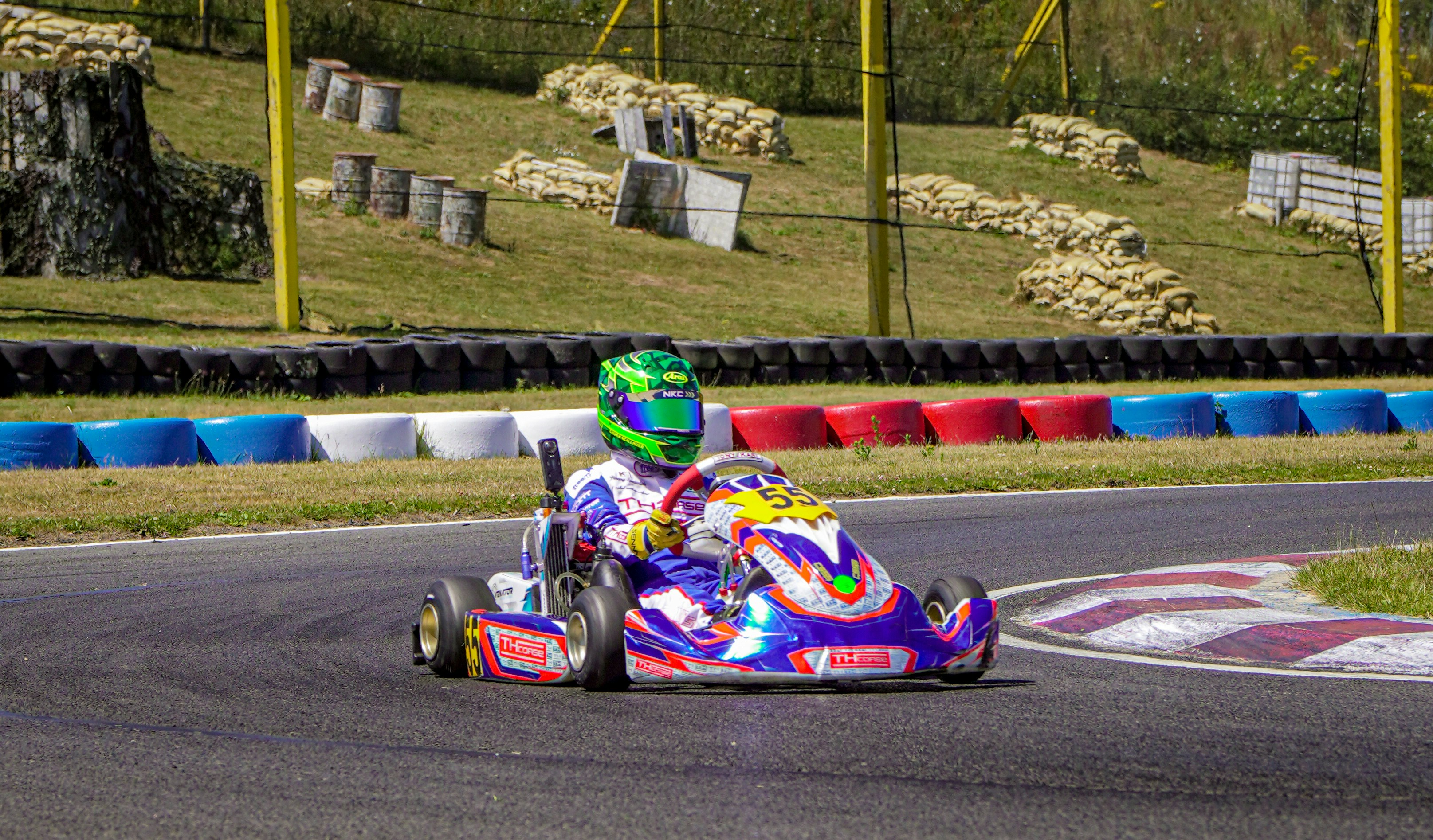 A go-kart racer speeds around a corner on a track.