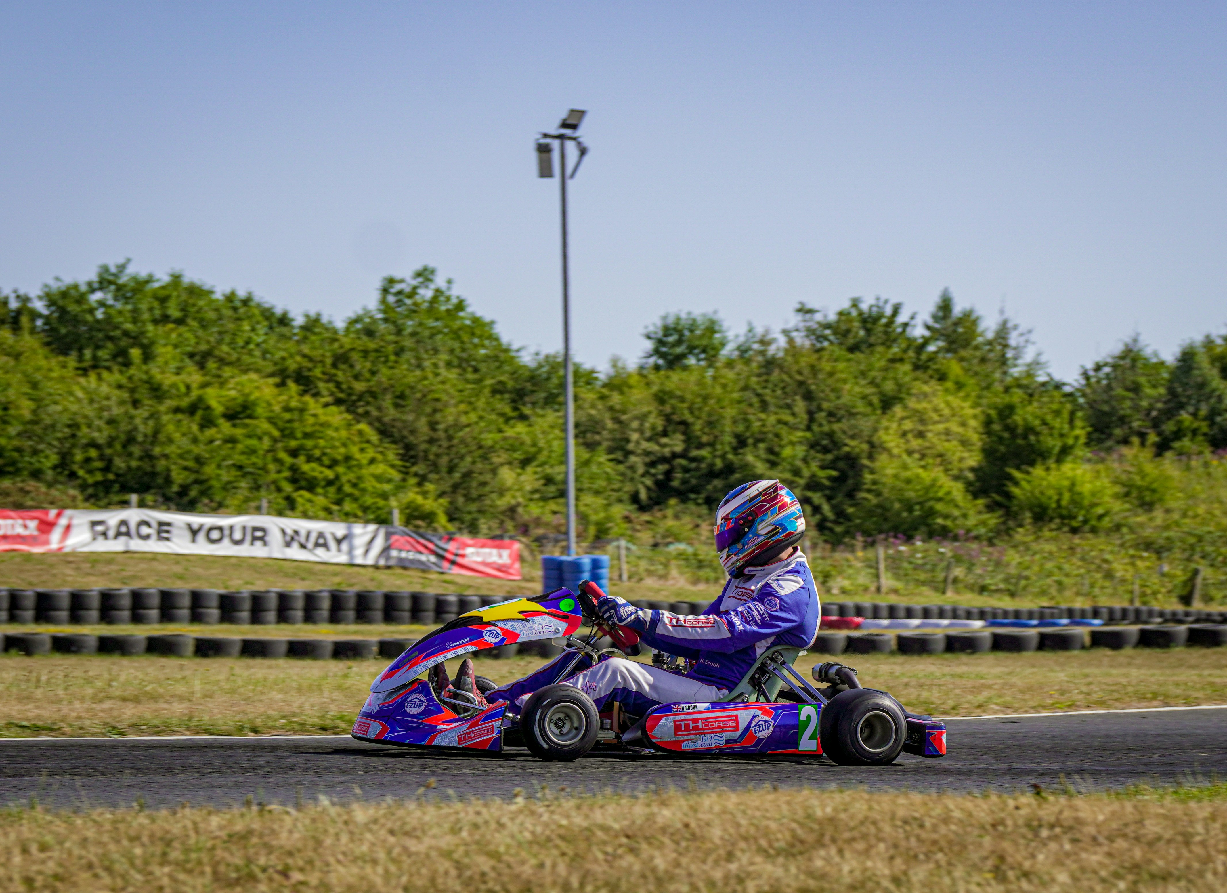Pengemudi berjas balap di go-kart warna-warni