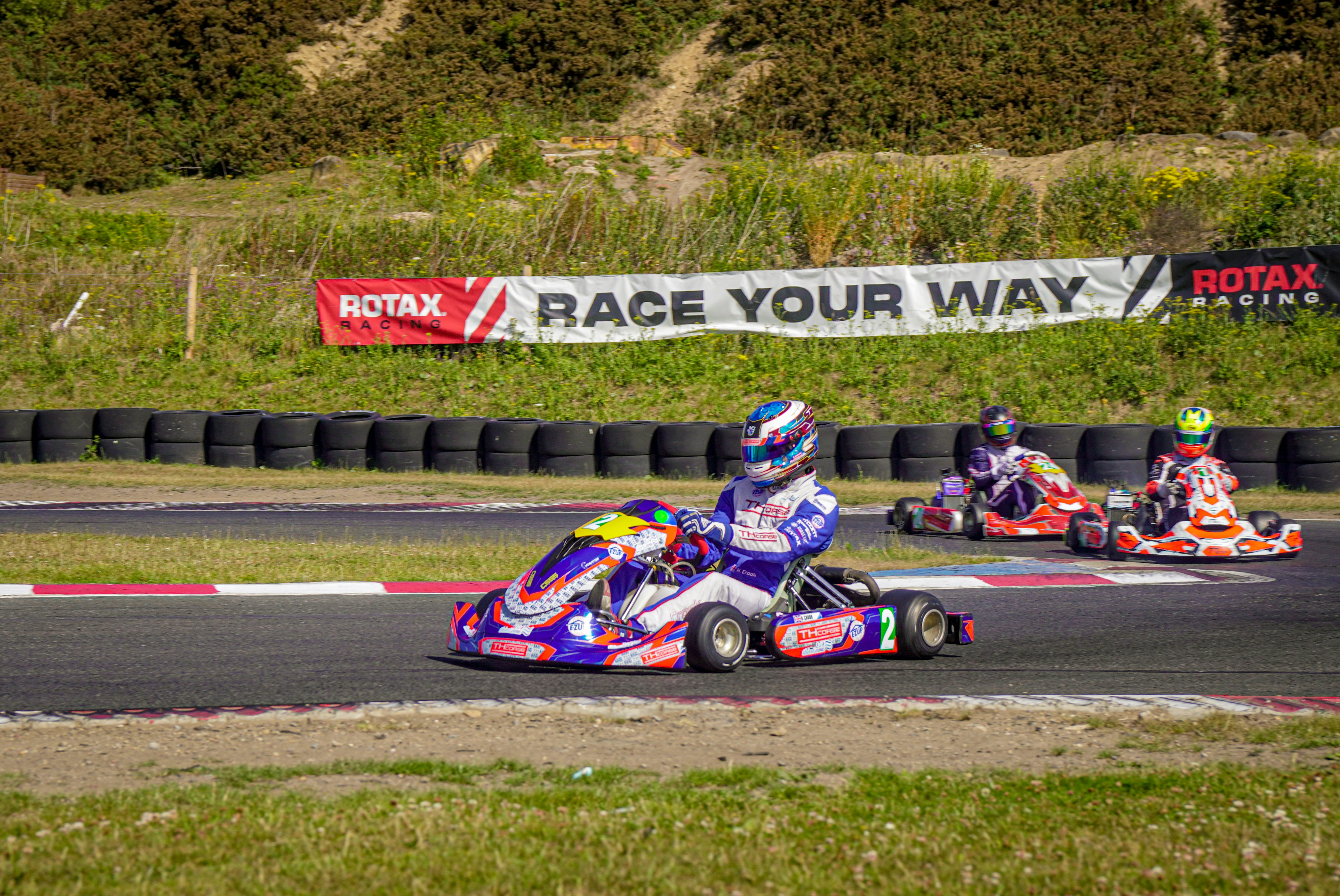 Children racing go-karts on a sunny track