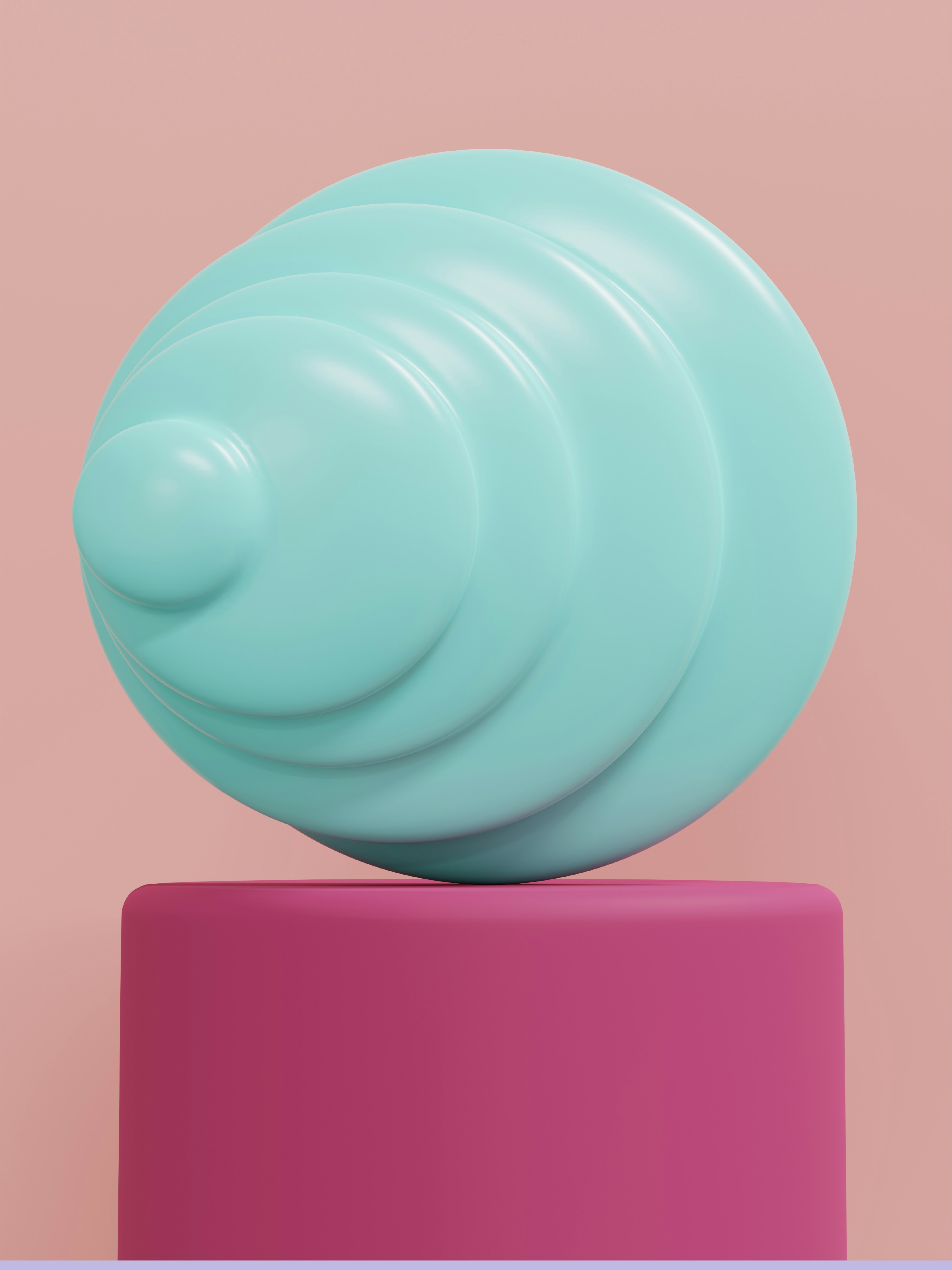 A blue layered sphere rests on a pink cube.