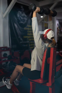 Woman is lifting weights at the gym.