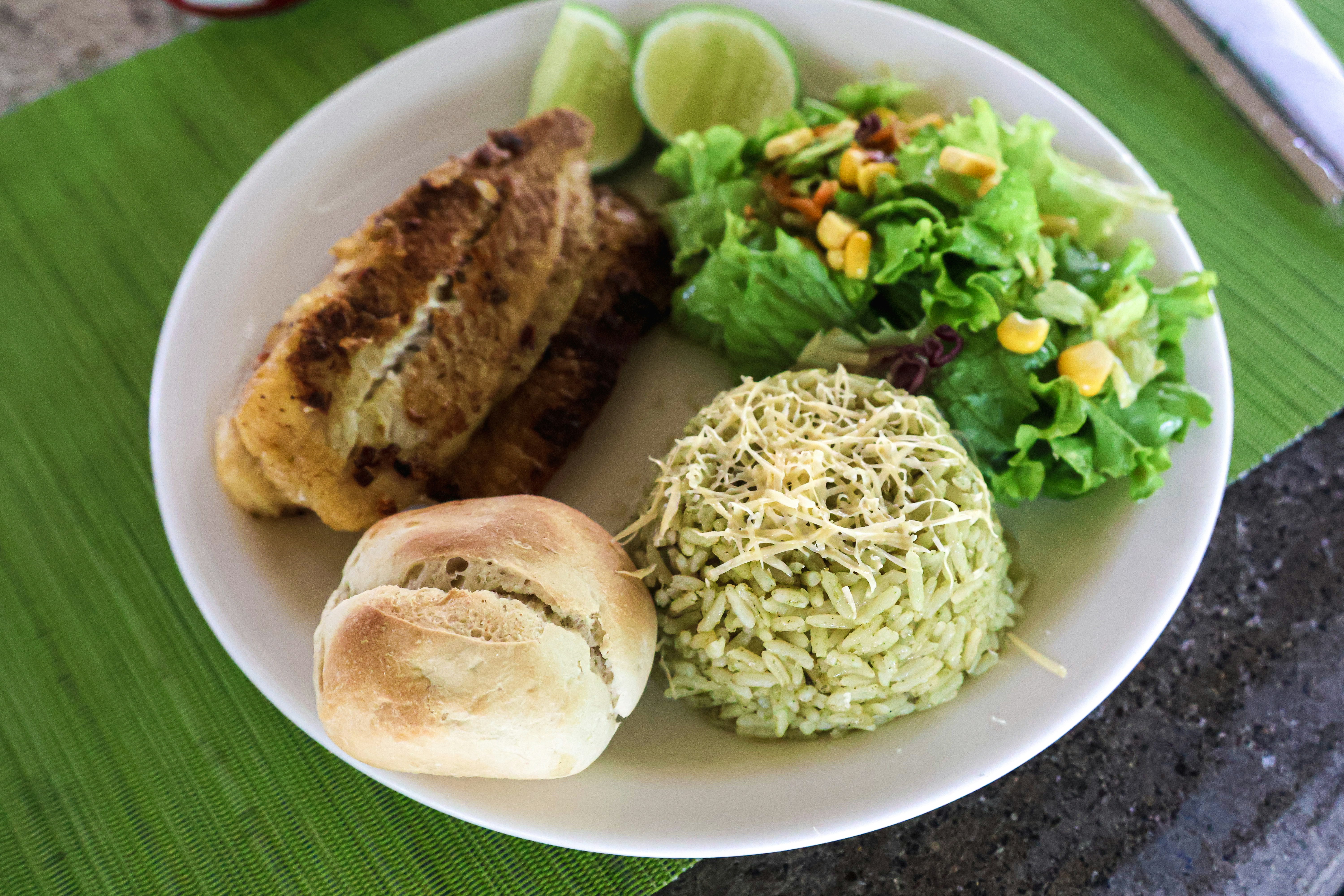 A plate of food with fish, rice, and salad.