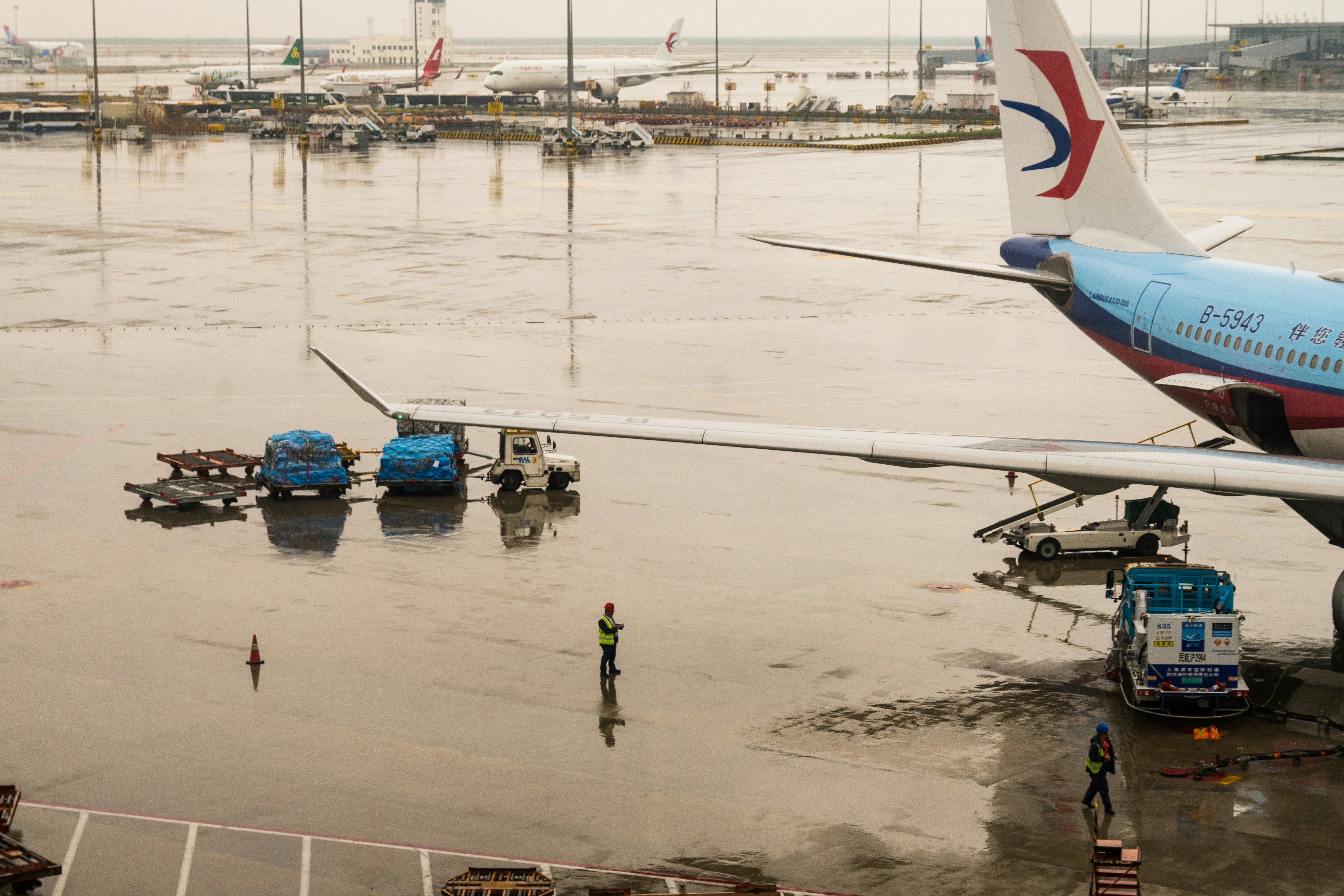 A rainy airport is flooded near the plane.