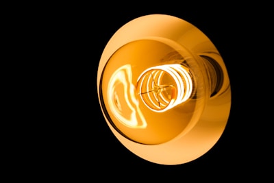 A bright light bulb illuminates against darkness.