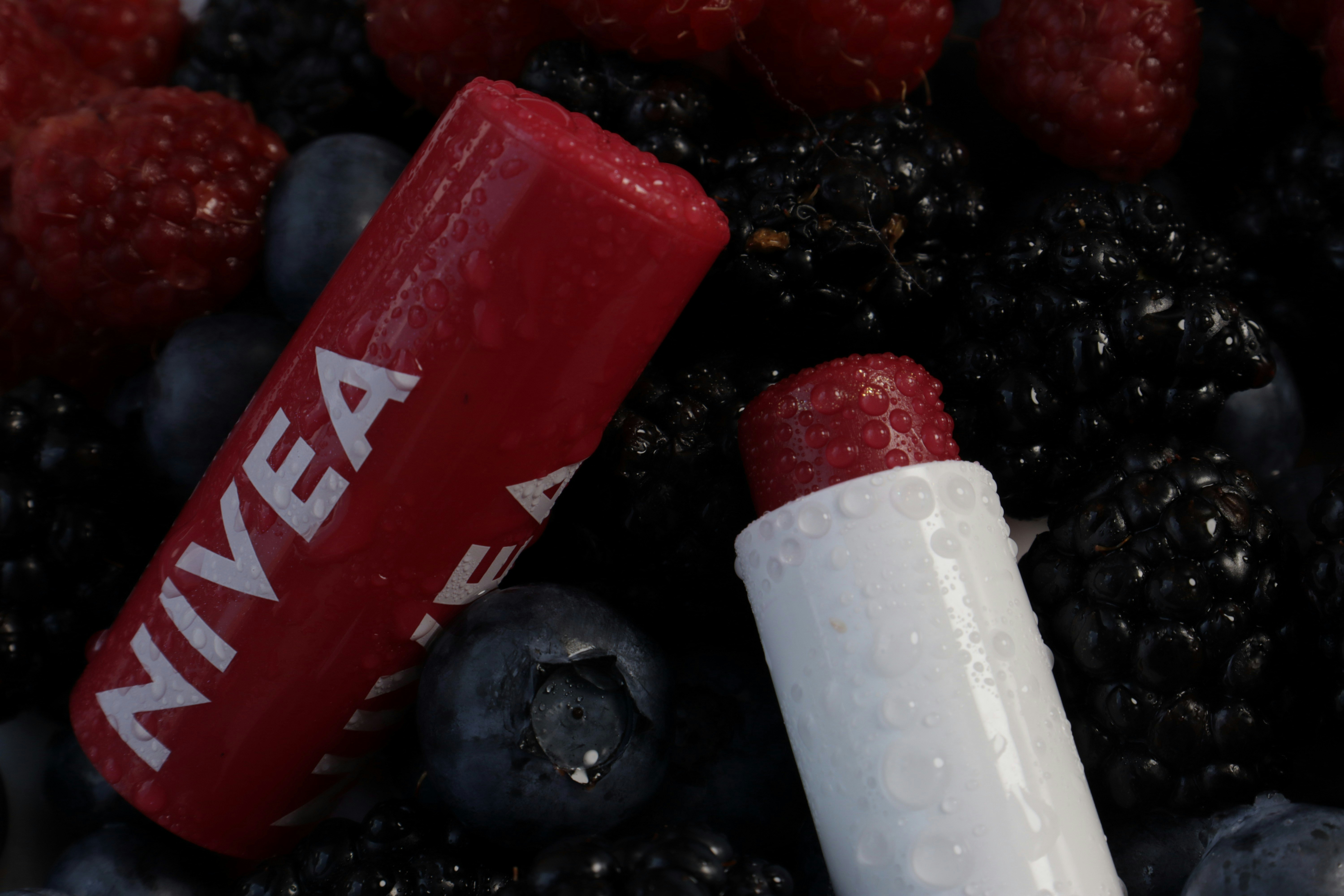 Nivea lip balm rests among various berries.
