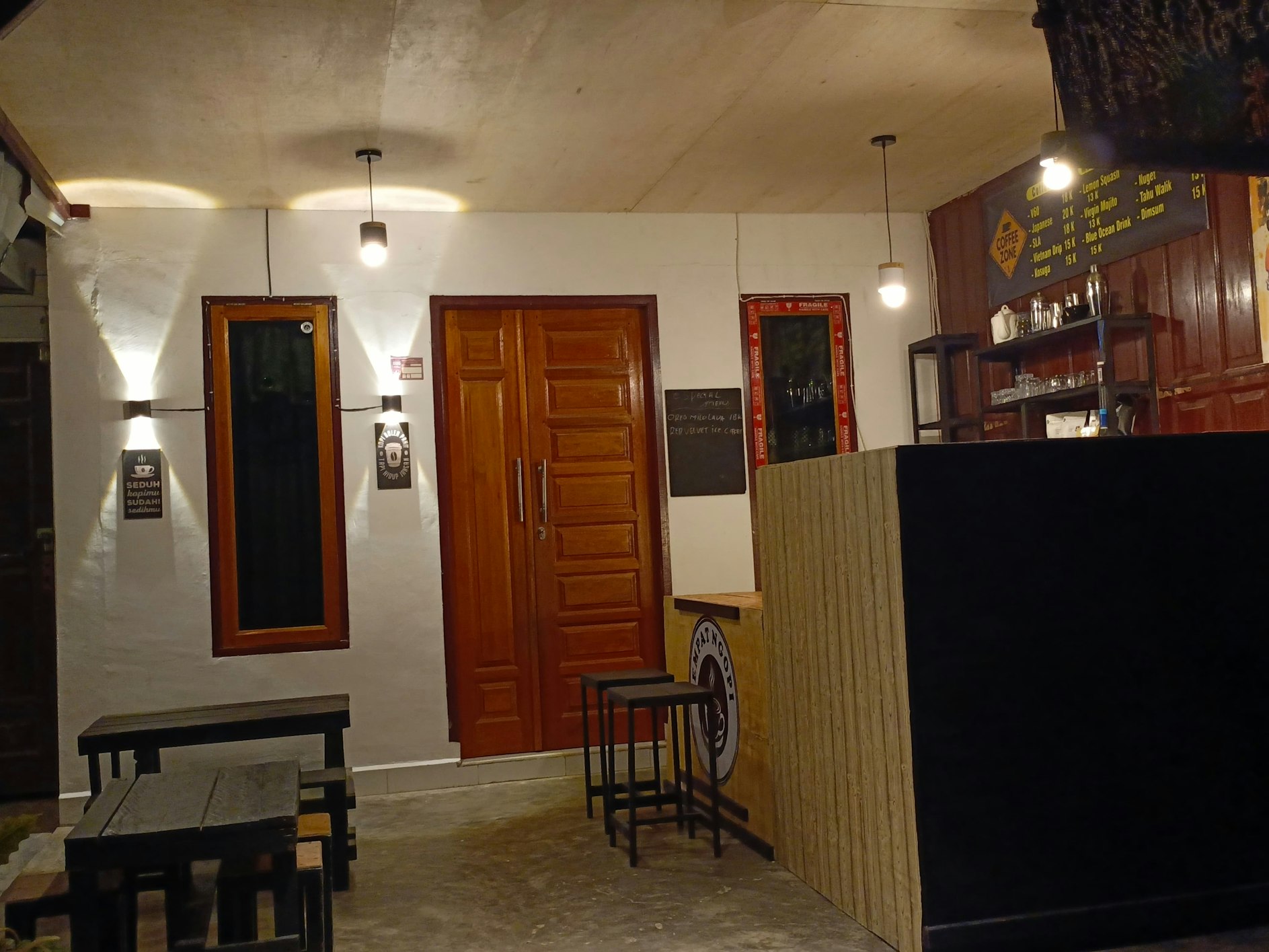 Interior Kafe TempatNgopi.com yang estetik dengan kursi-kursi kayu dan dekorasi minimalis.