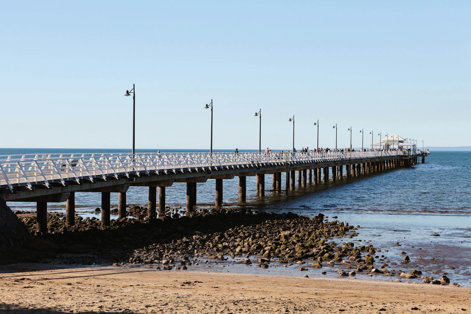 A long pier stretches into the ocean.