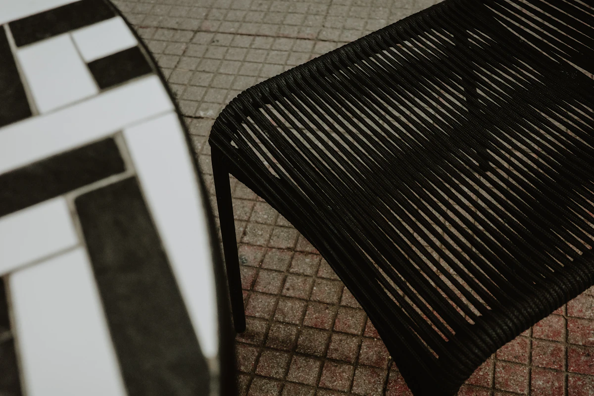 A black chair and table are outdoors.