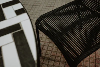 A black chair and table are outdoors.