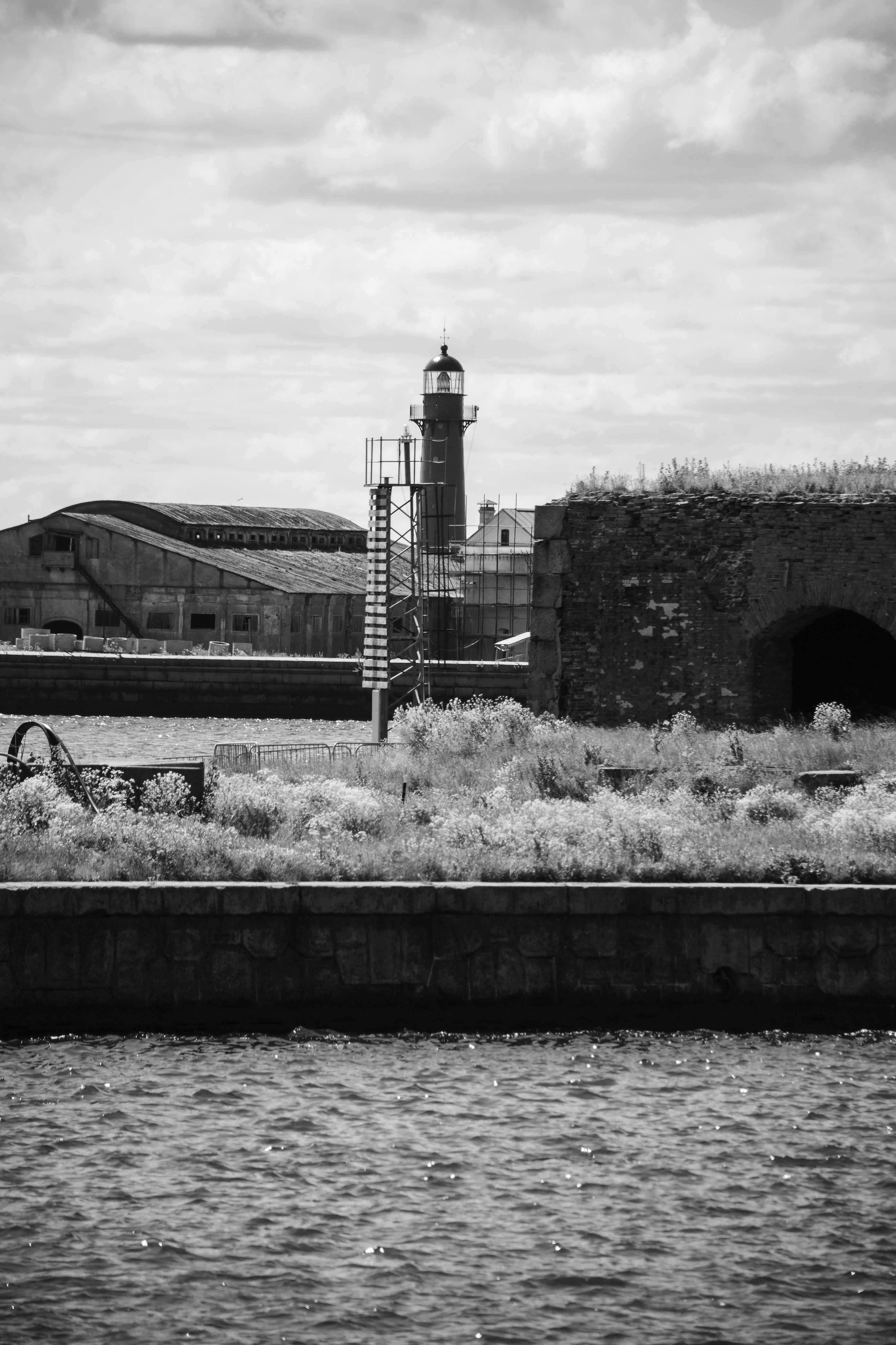 A lighthouse towers over a weathered seascape.