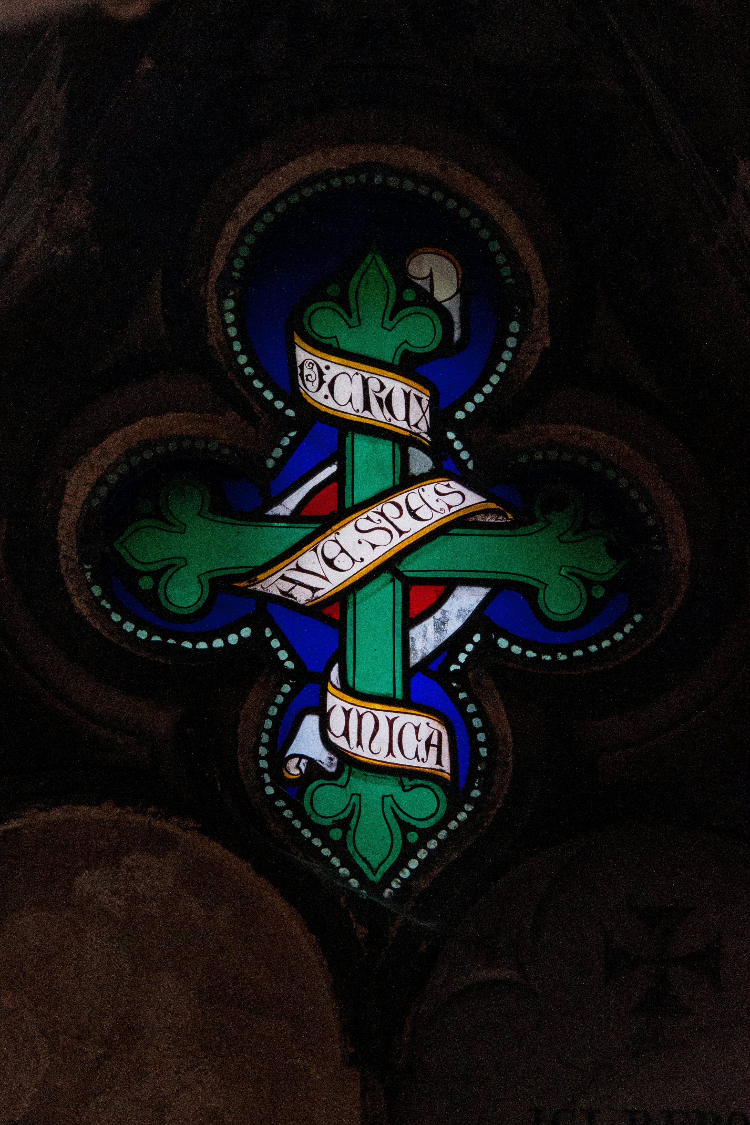 Una colorida cruz de vidrieras adorna una ventana.