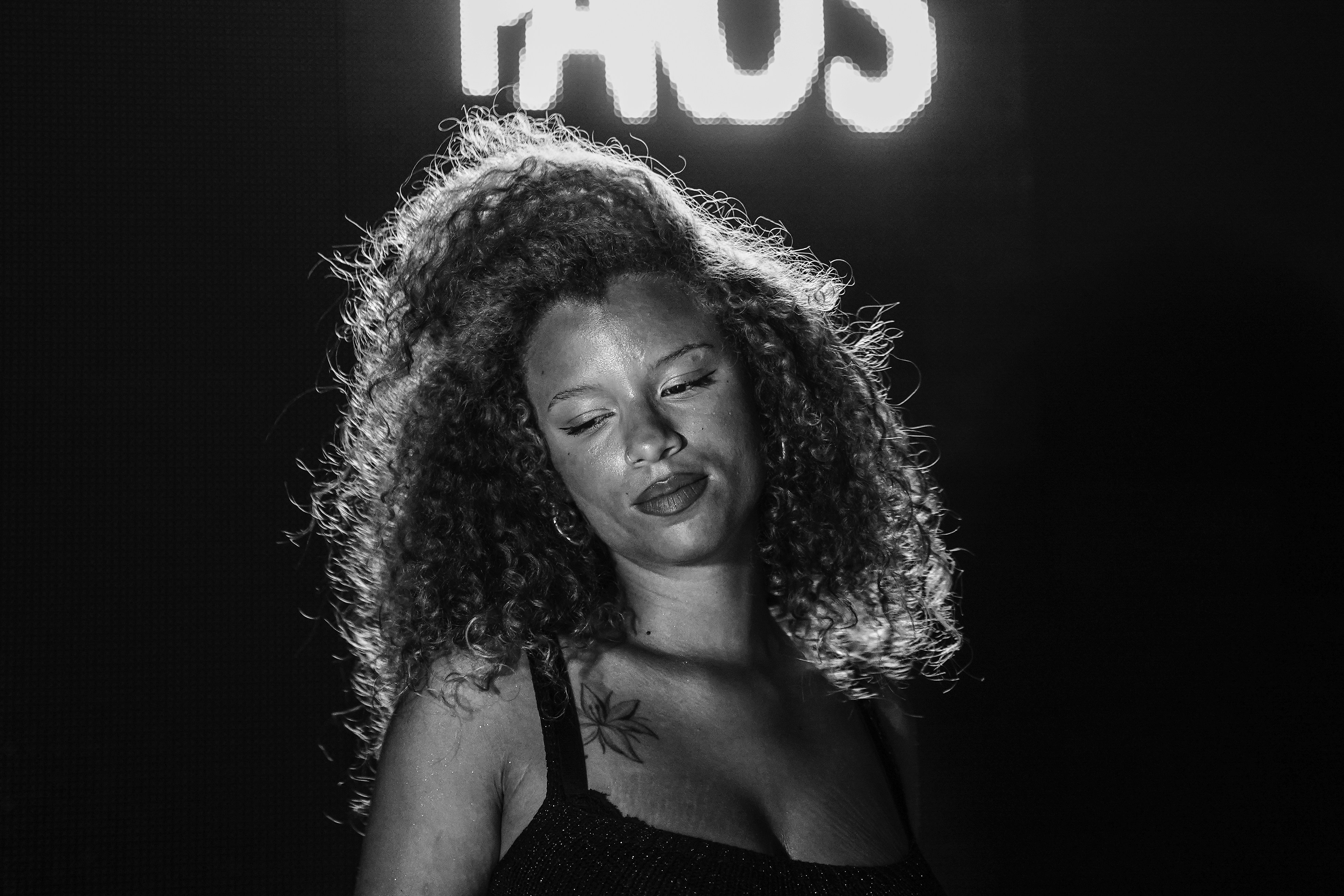 Woman with large hair poses under bright lights.
