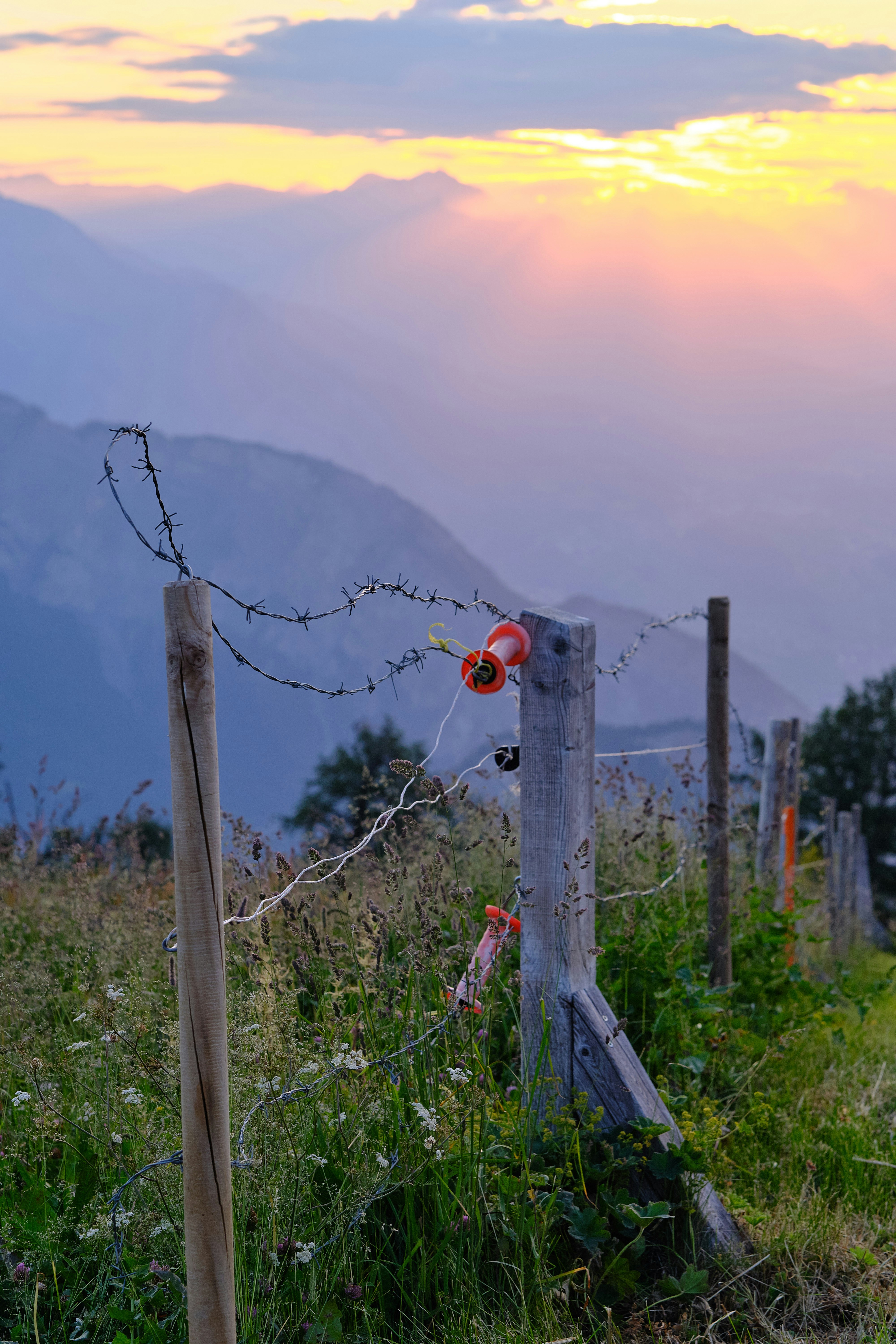 Fence silhouetted against a beautiful sunset in the mountains.