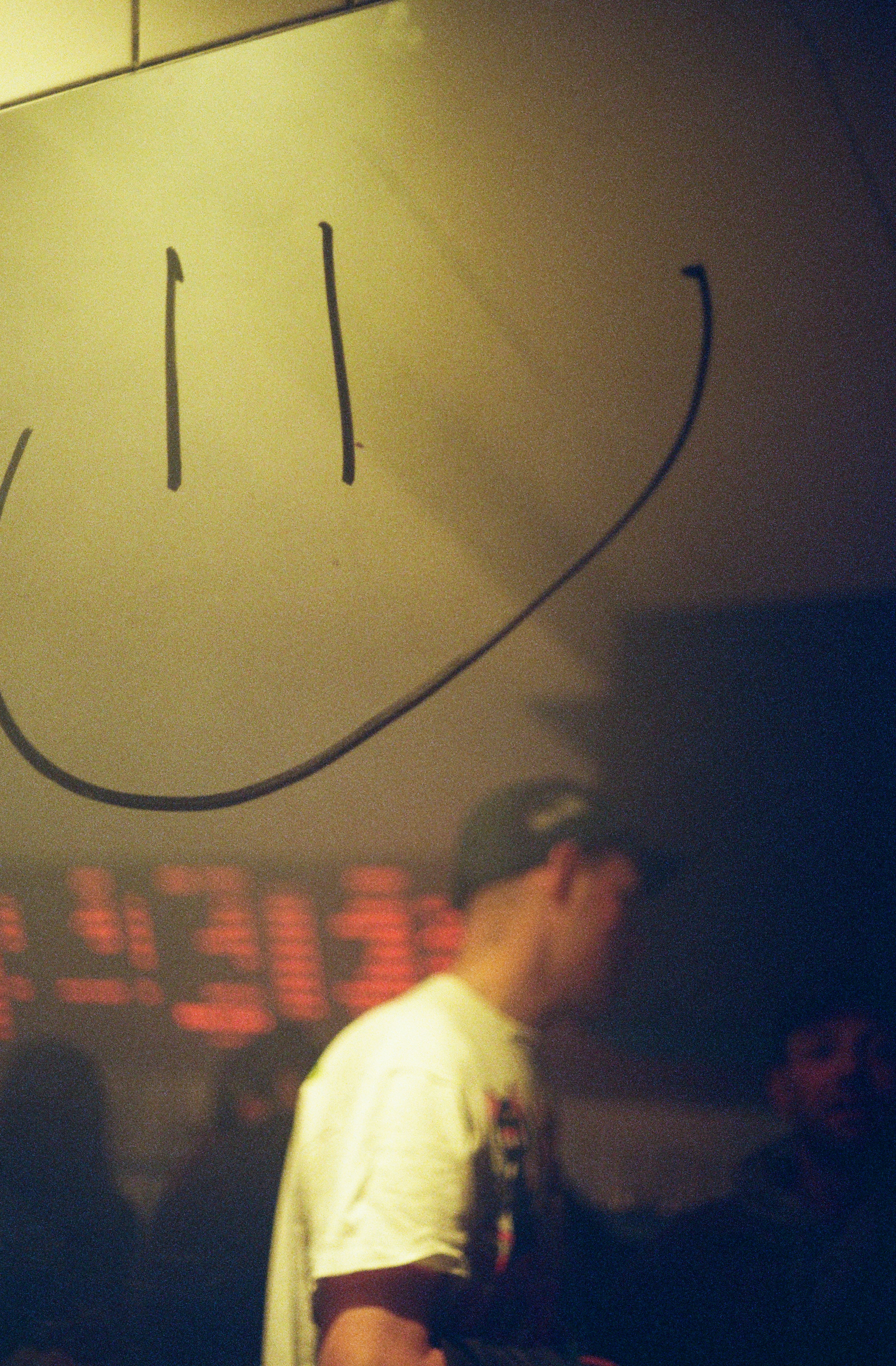 A smiley face is above a crowd of people