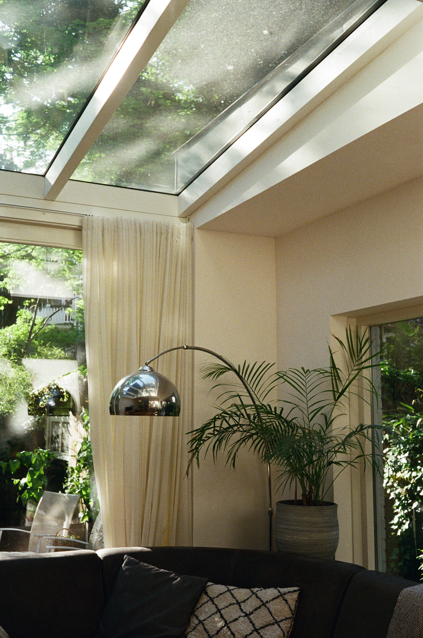 Sunlit garden room with a glazed roof and plants