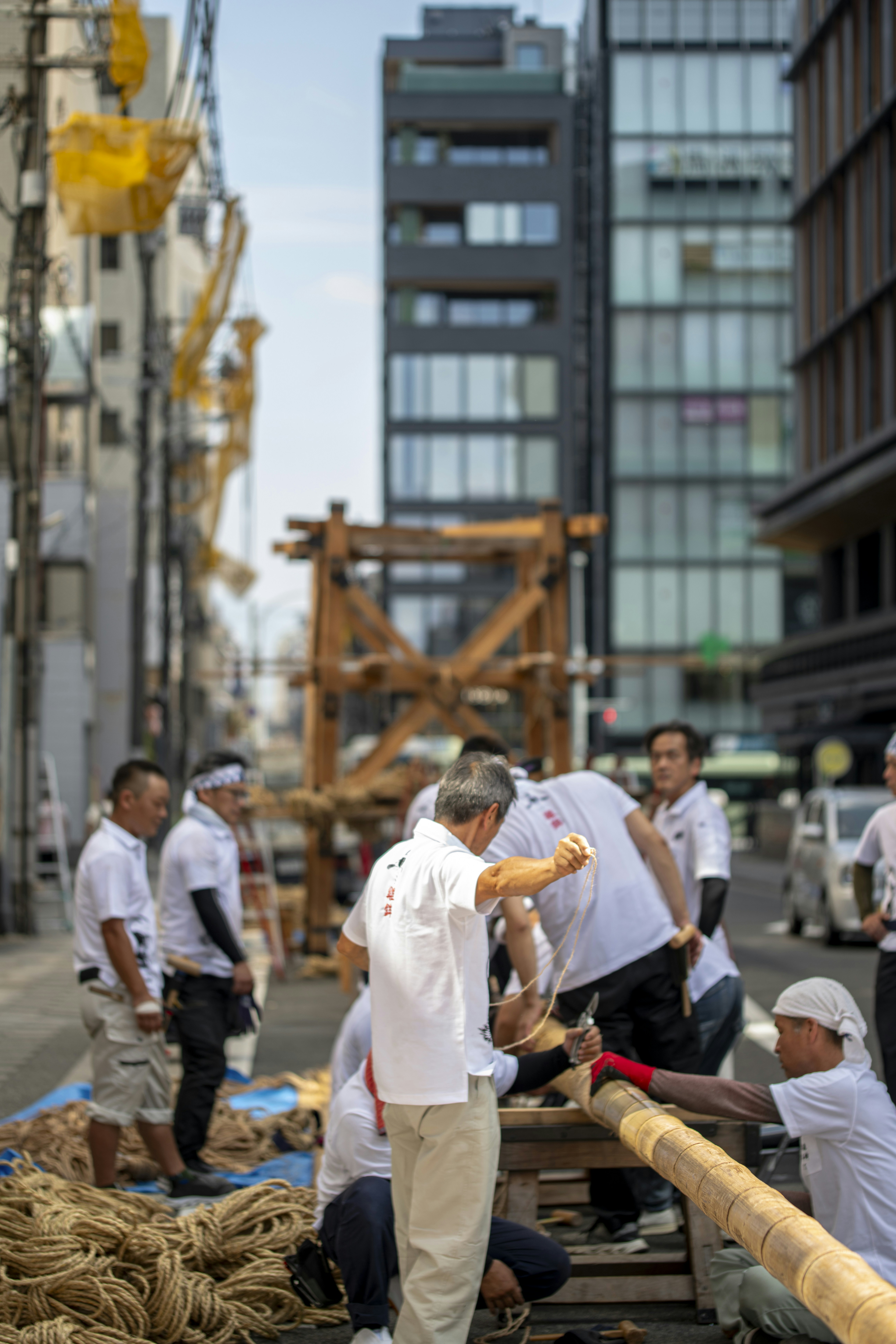 Men are working on a wooden structure in the street.