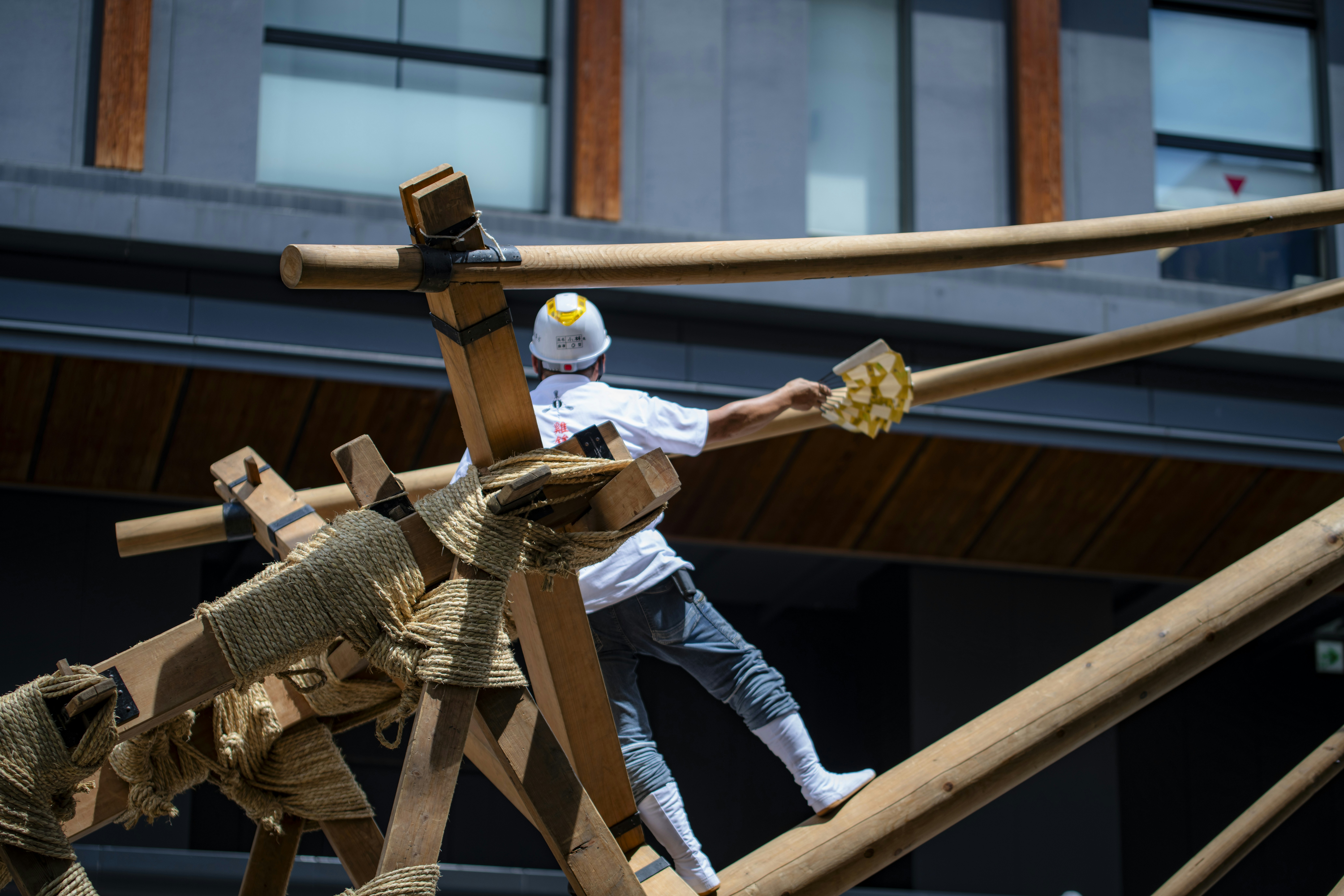 A worker is on wooden scaffold construction.