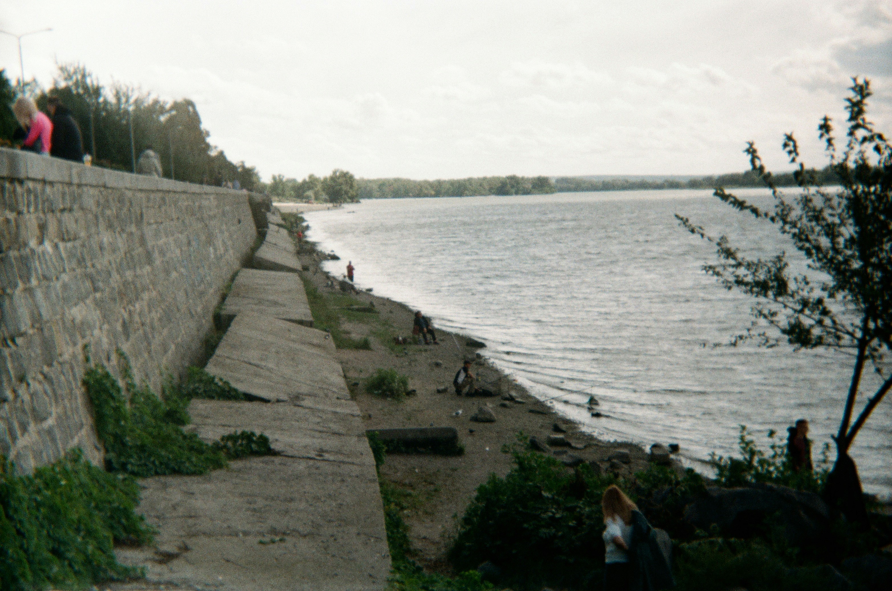 A waterside embankment borders a calm lake.