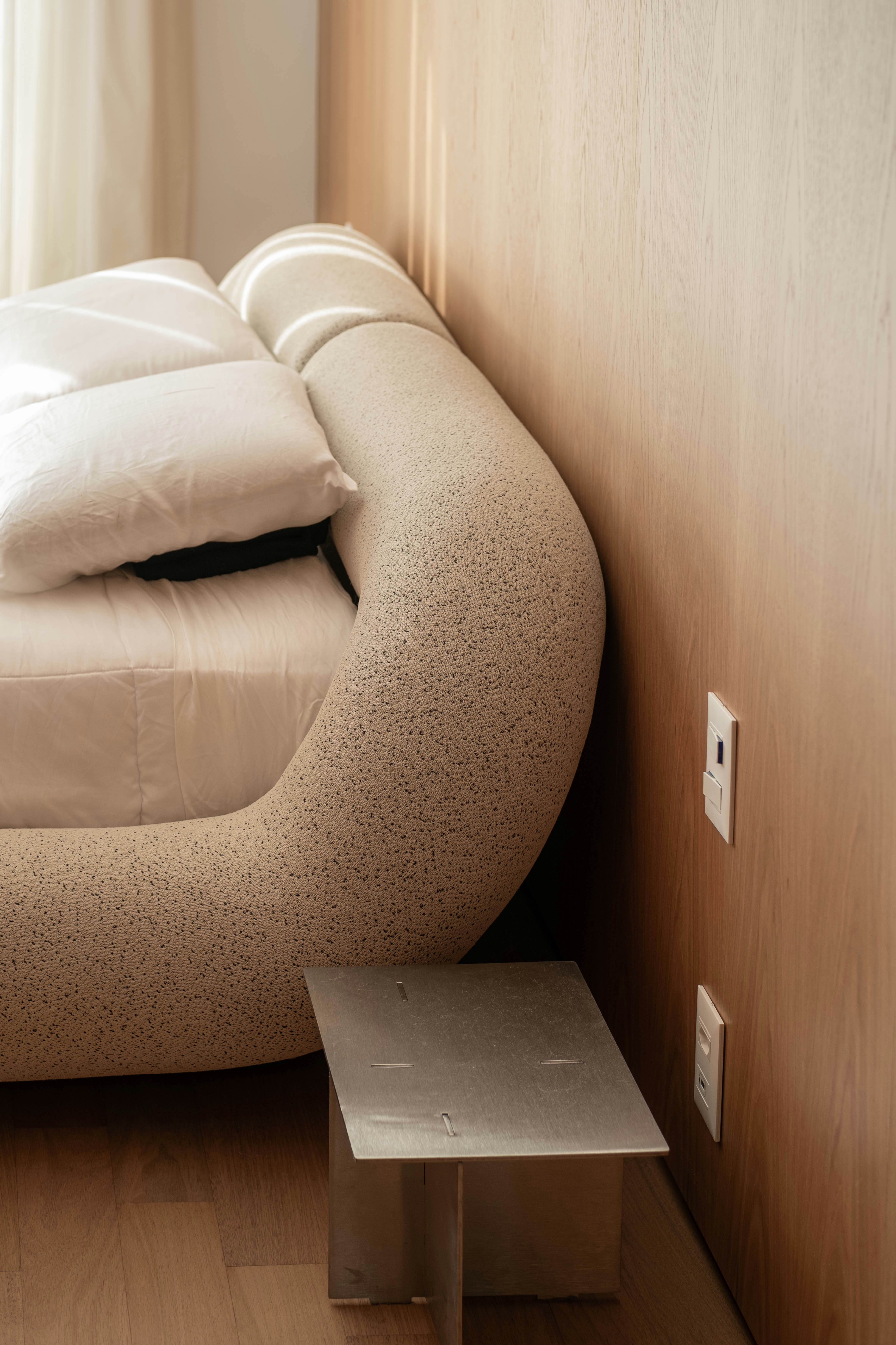 A modern bedroom shows a cozy bed.