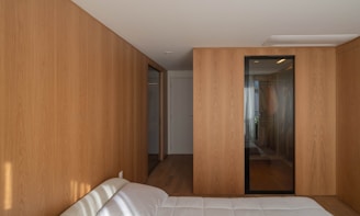 A bedroom features wooden walls and doors.