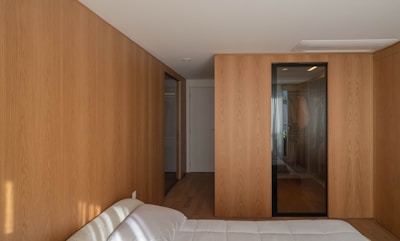 A bedroom features wooden walls and doors.