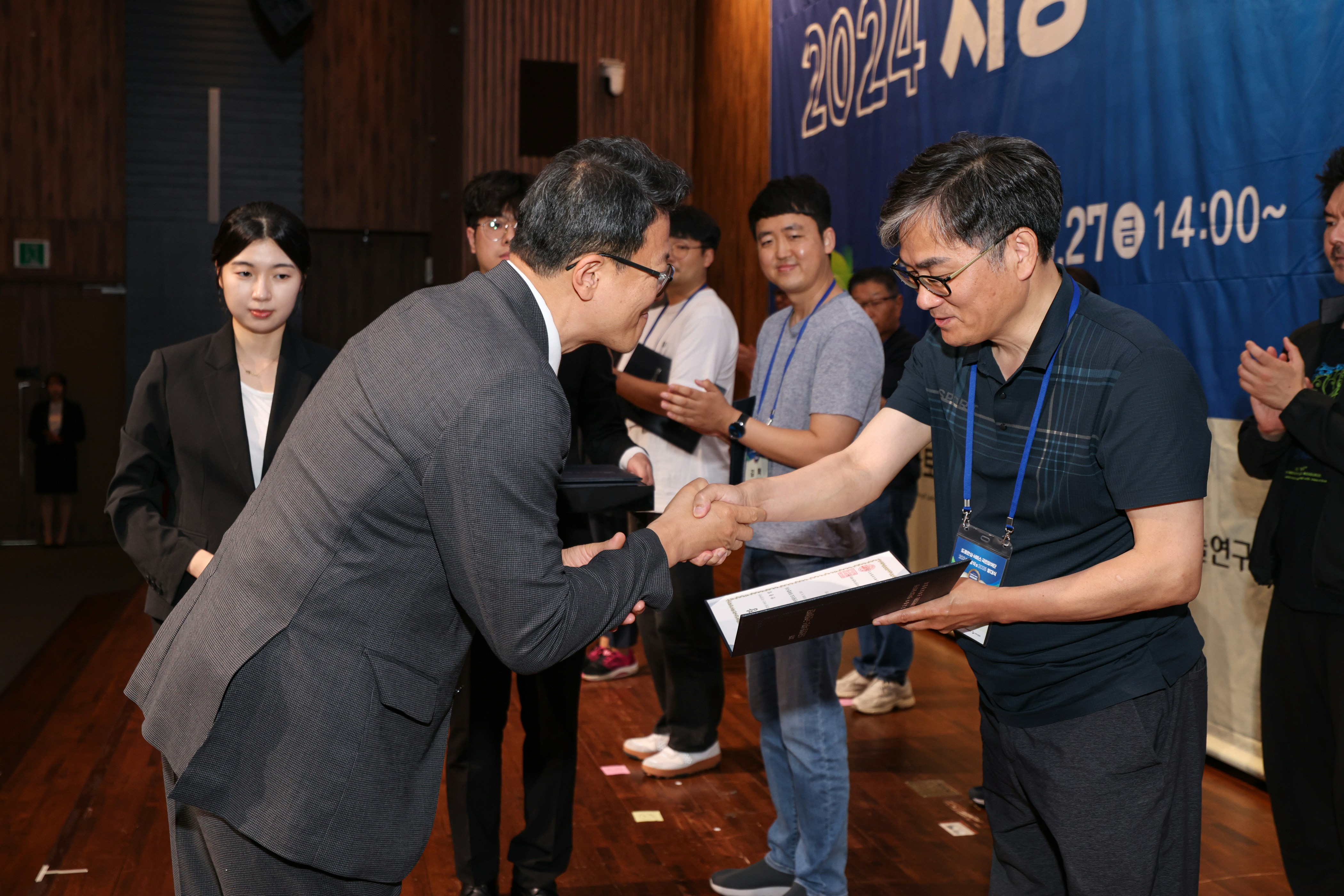 A man is accepting an award and shaking hands.