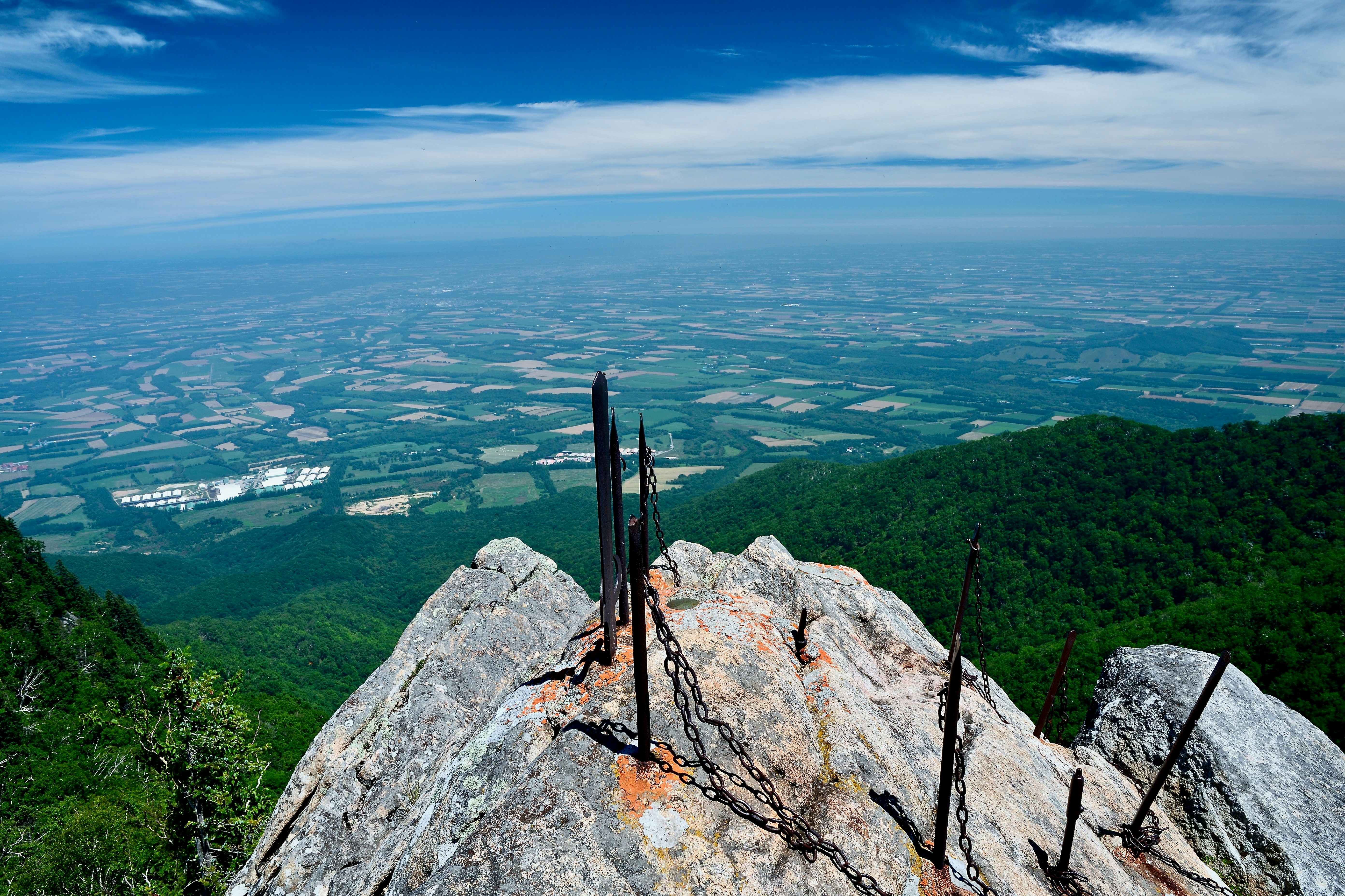 A mountain peak overlooks a vast, scenic landscape.