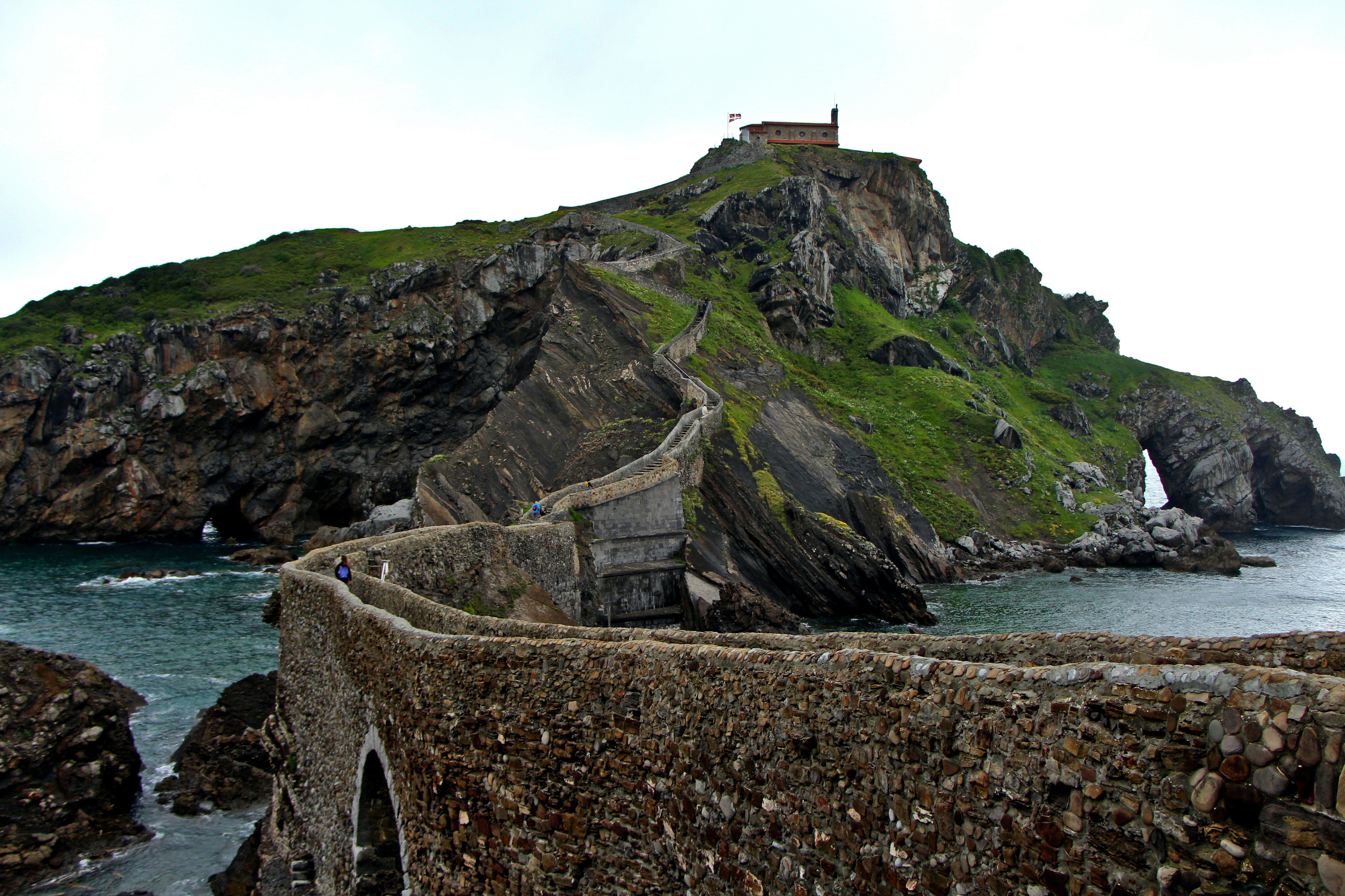A stone bridge leads to an island with a church.