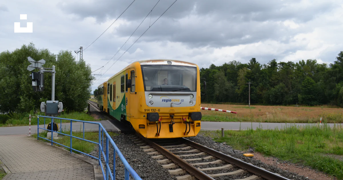 Train Yellow Ramp A yellow train is approaching a railroad crossing. photo – Free Train ...