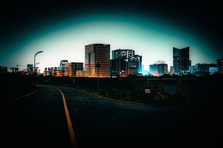A road leads to a city at night.